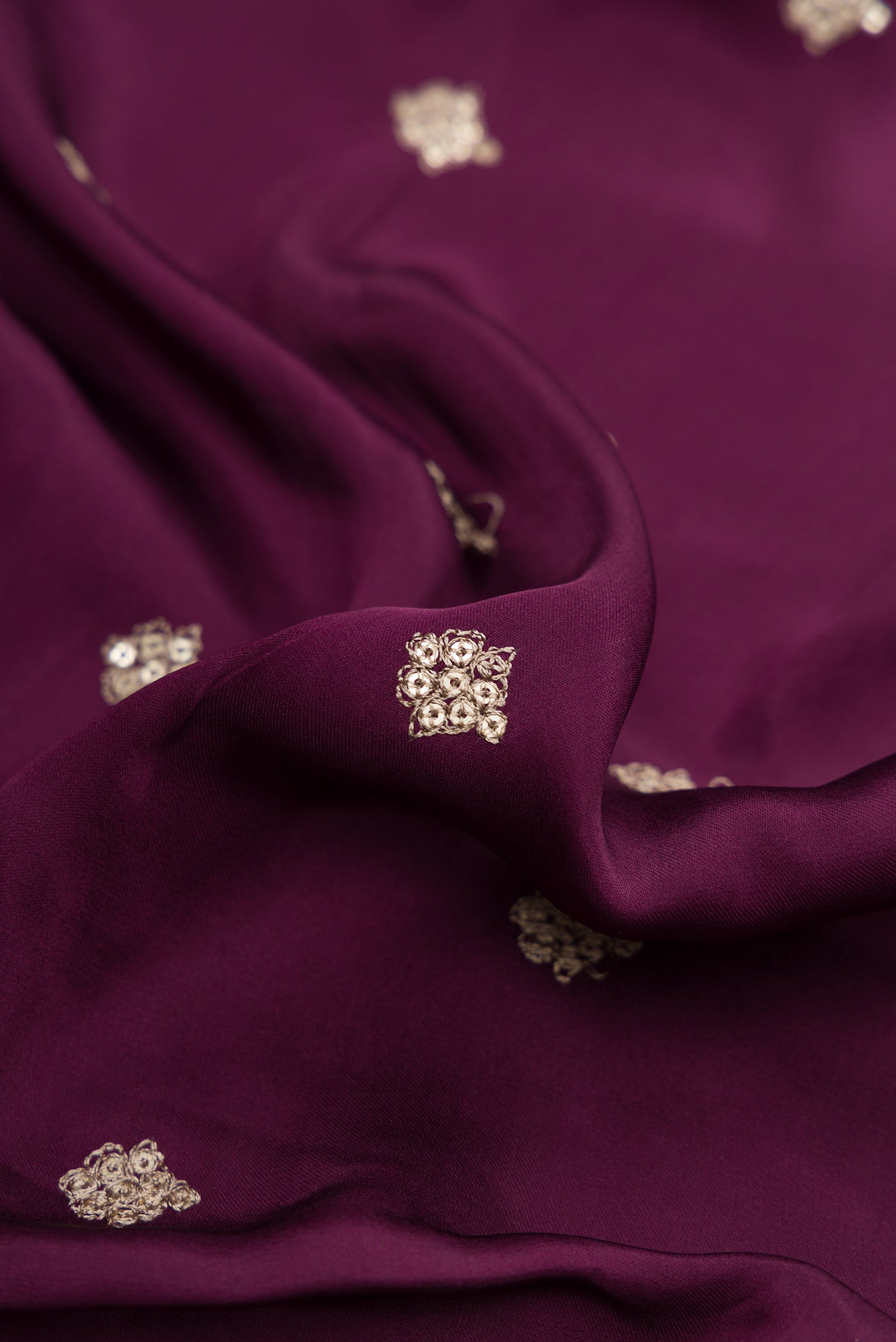 Close up of Burgundy Dual Tone Mysore Crepe Saree with Embroidery on the body and Embroidery Border.  displaying folds