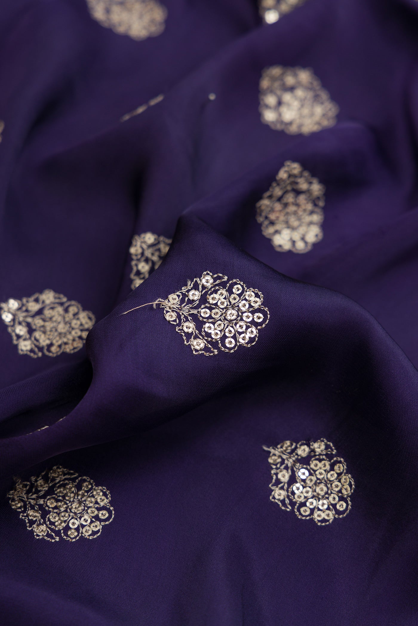 Close up of Navy Blue Dual Tone Crepe Saree with Embroidery on the body and Embroidery Border.  displaying folds