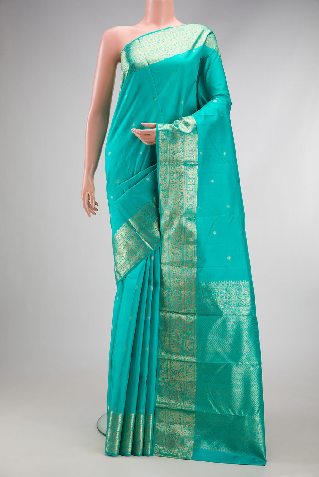 Turquoise Kanchipuram Silk Saree with Zari Butta on the body and Zari Border.  displayed on a mannequin