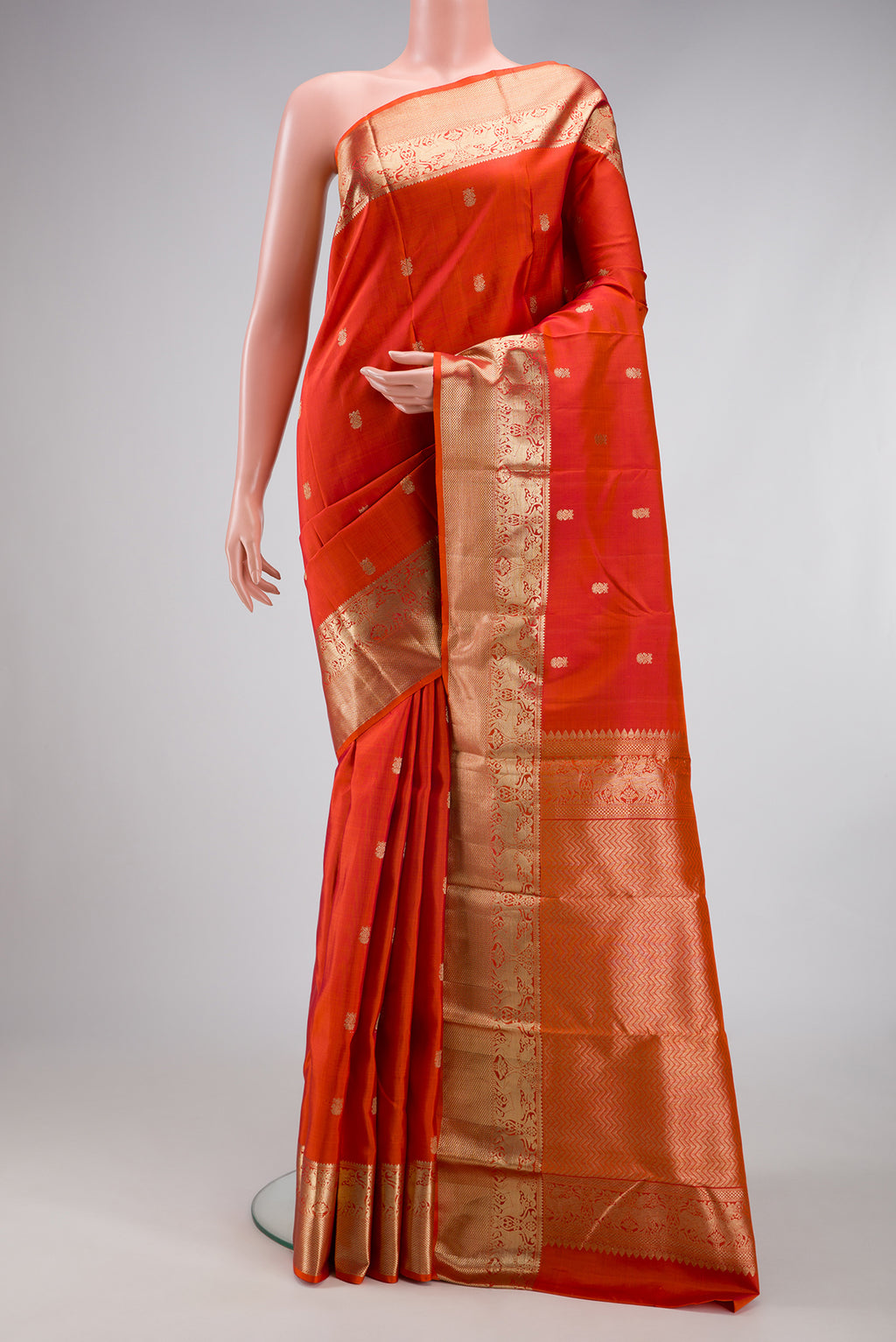 Orange Dual Tone Kanchipuram Silk Saree with Zari Butta on the body and Zari Border.  displayed on a mannequin
