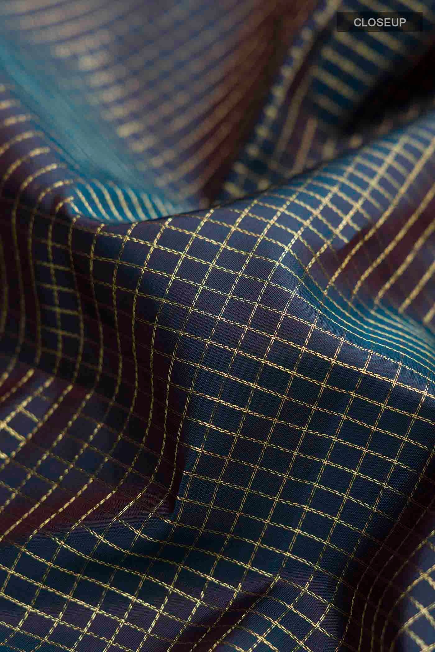 Close up of Blue Kanchipuram Silk Saree with Checked design on the body and Zari Border displaying folds