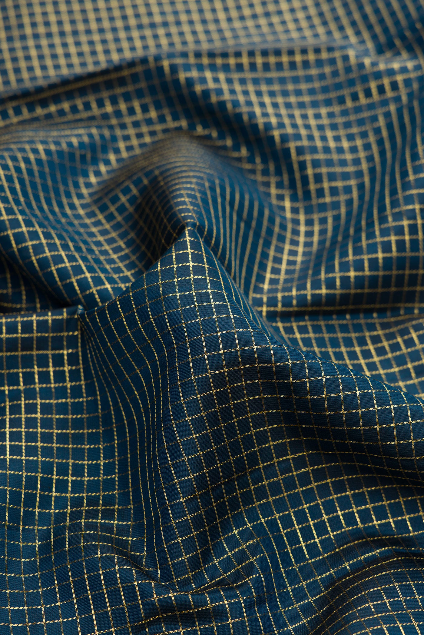 Close up of Peacock Blue Dual Tone Kanchipuram Silk Saree with Checked design on the body and Zari Border.  displaying folds