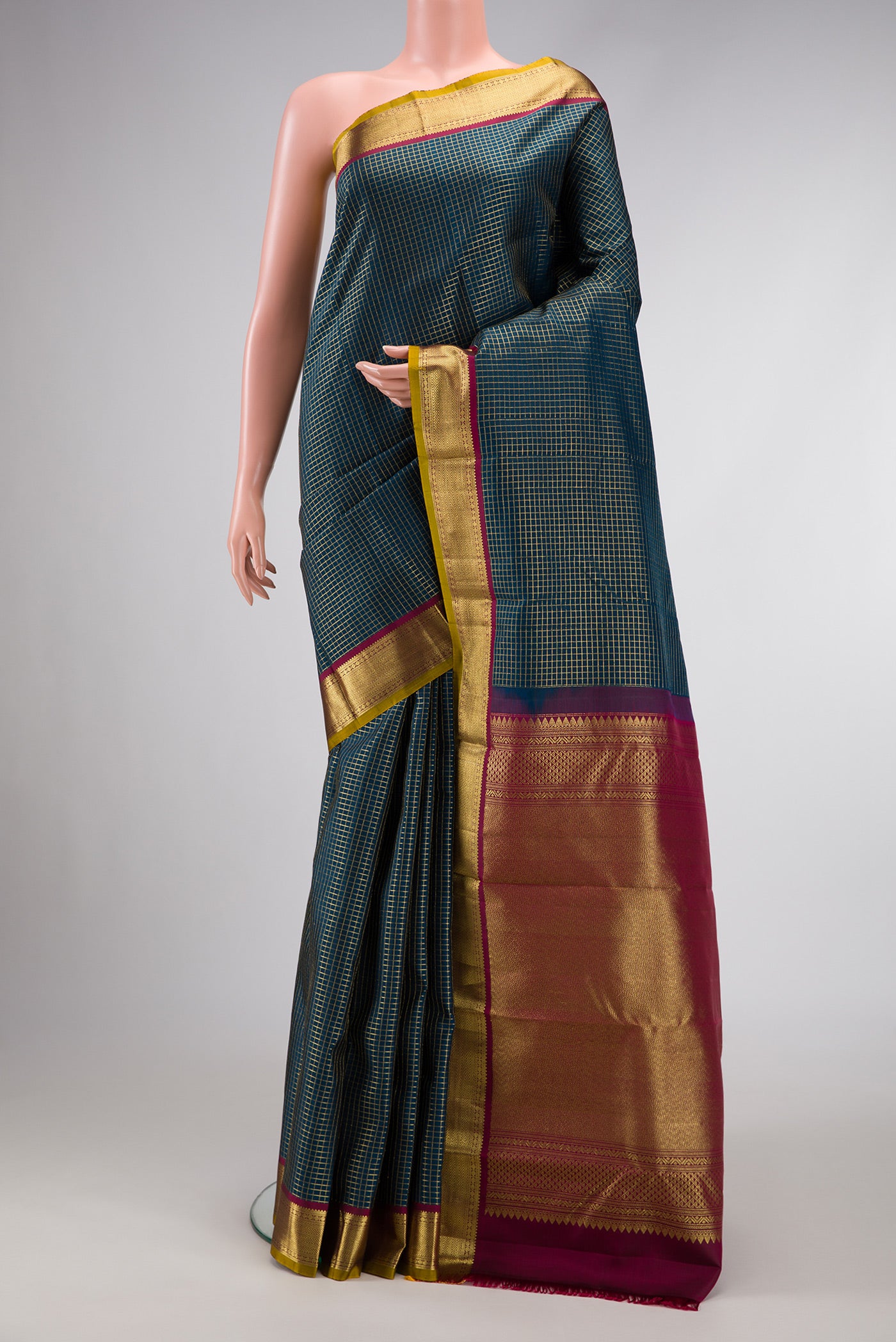 Peacock Blue Dual Tone Kanchipuram Silk Saree with Checked design on the body and Zari Border.  displayed on a mannequin