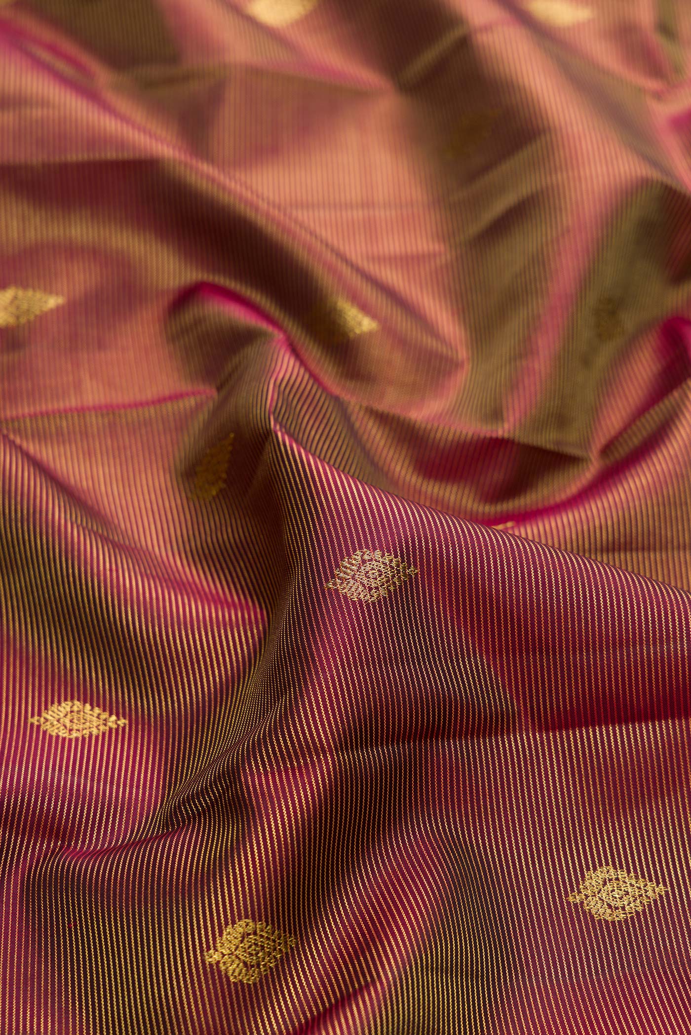 Close up of Brown Dual Tone Kanchipuram Silk Saree with Zari Butta on the body and Zari Border.  displaying folds