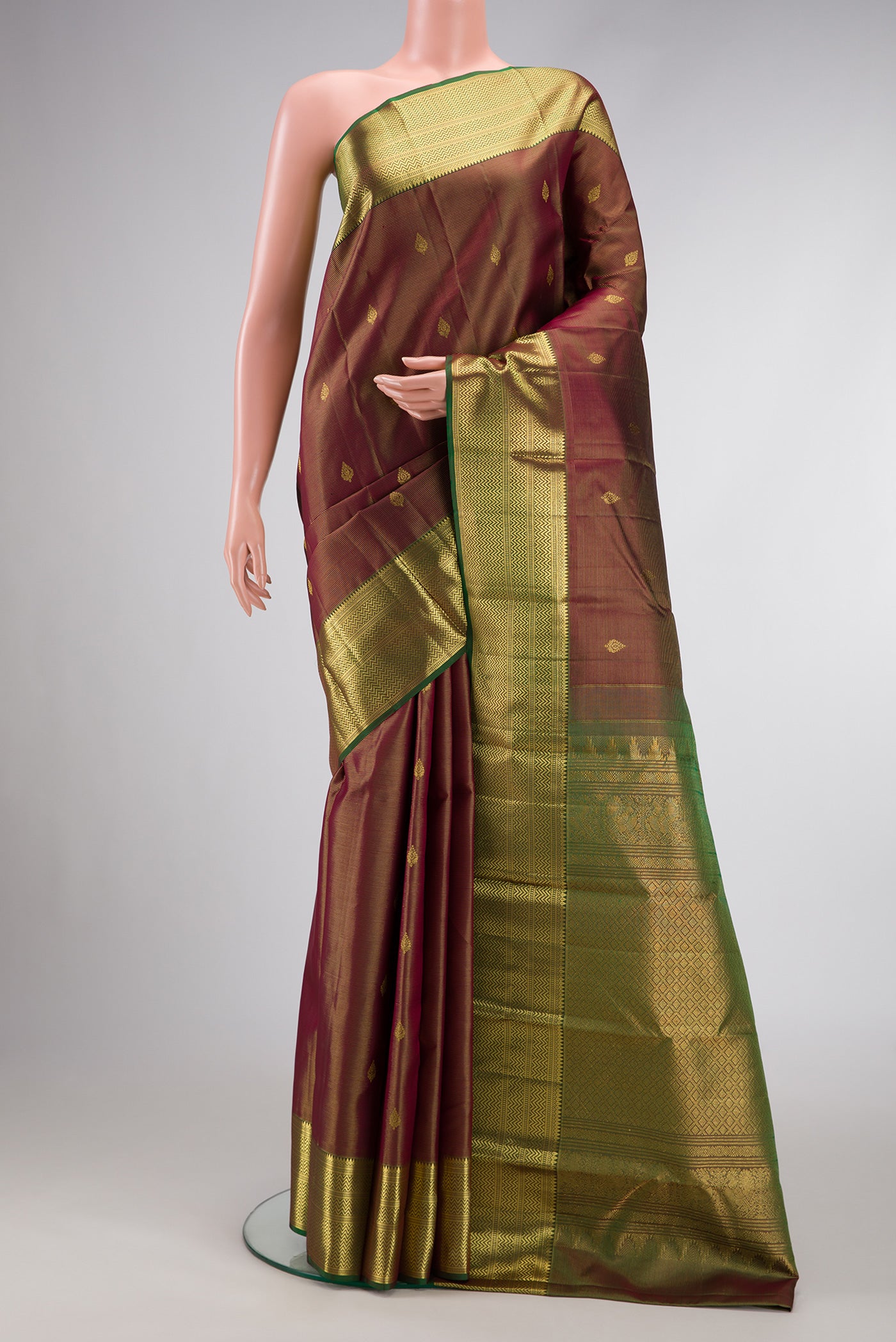 Brown Dual Tone Kanchipuram Silk Saree with Zari Butta on the body and Zari Border.  displayed on a mannequin