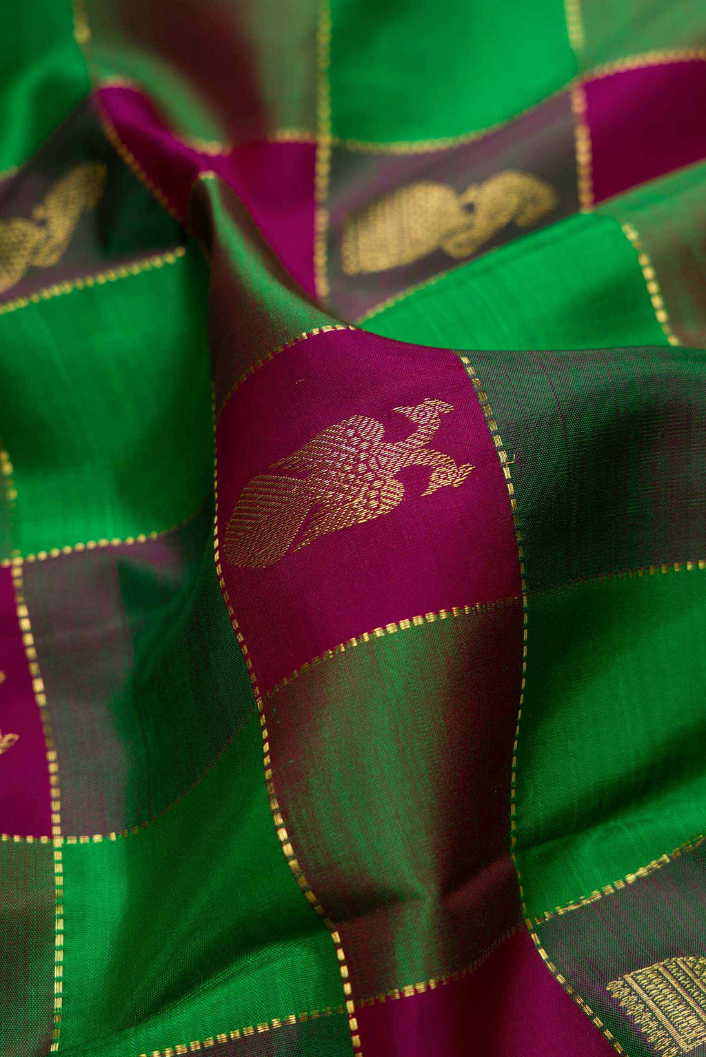 Close up of Green and Purple Color Kanchipuram Silk Saree with Checked design on the body and Zari Border displaying folds