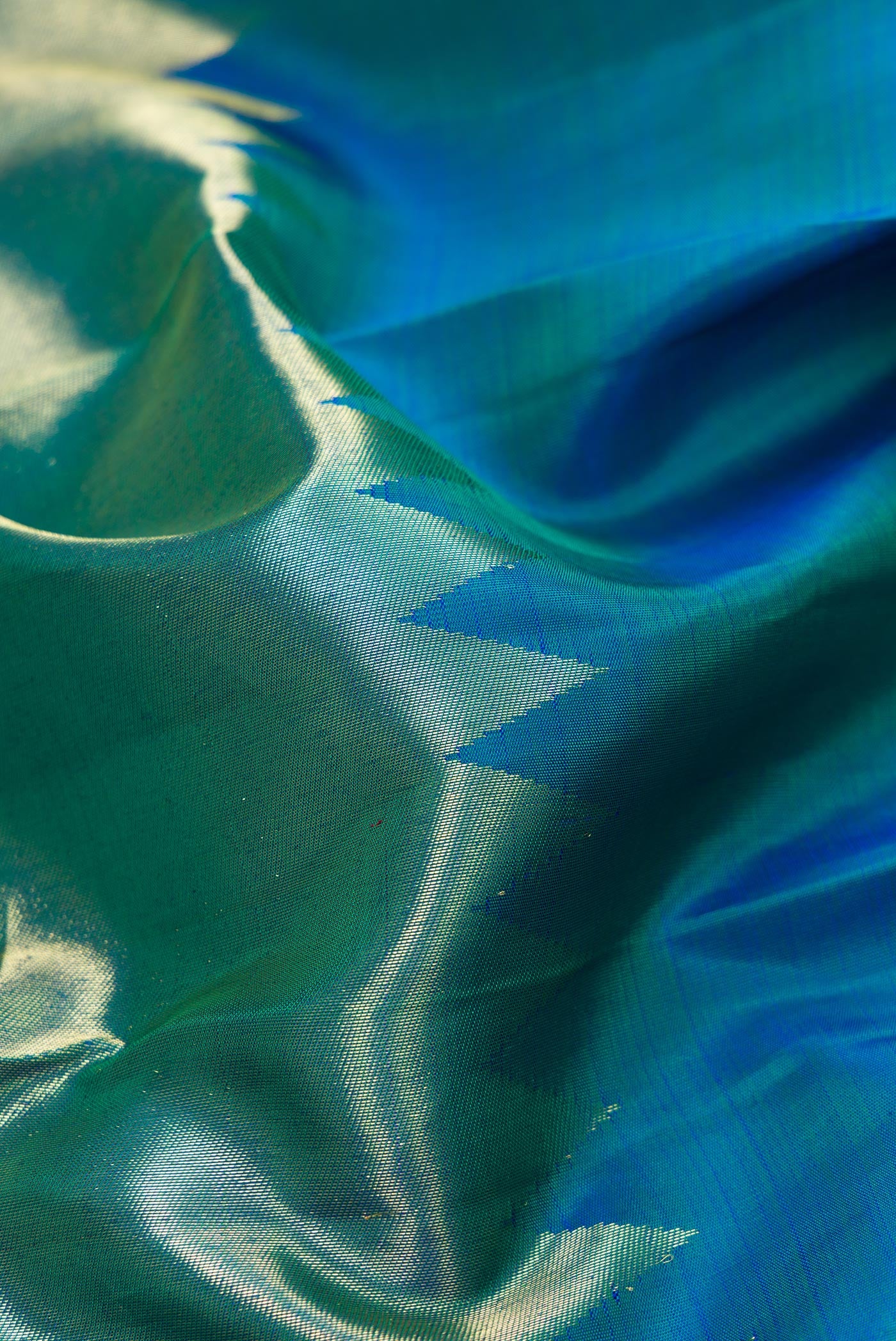 Close up of Peacock Blue Dual Tone Kanjivaram Silk Saree with Plain Body and Rising Temple Border.  displaying folds