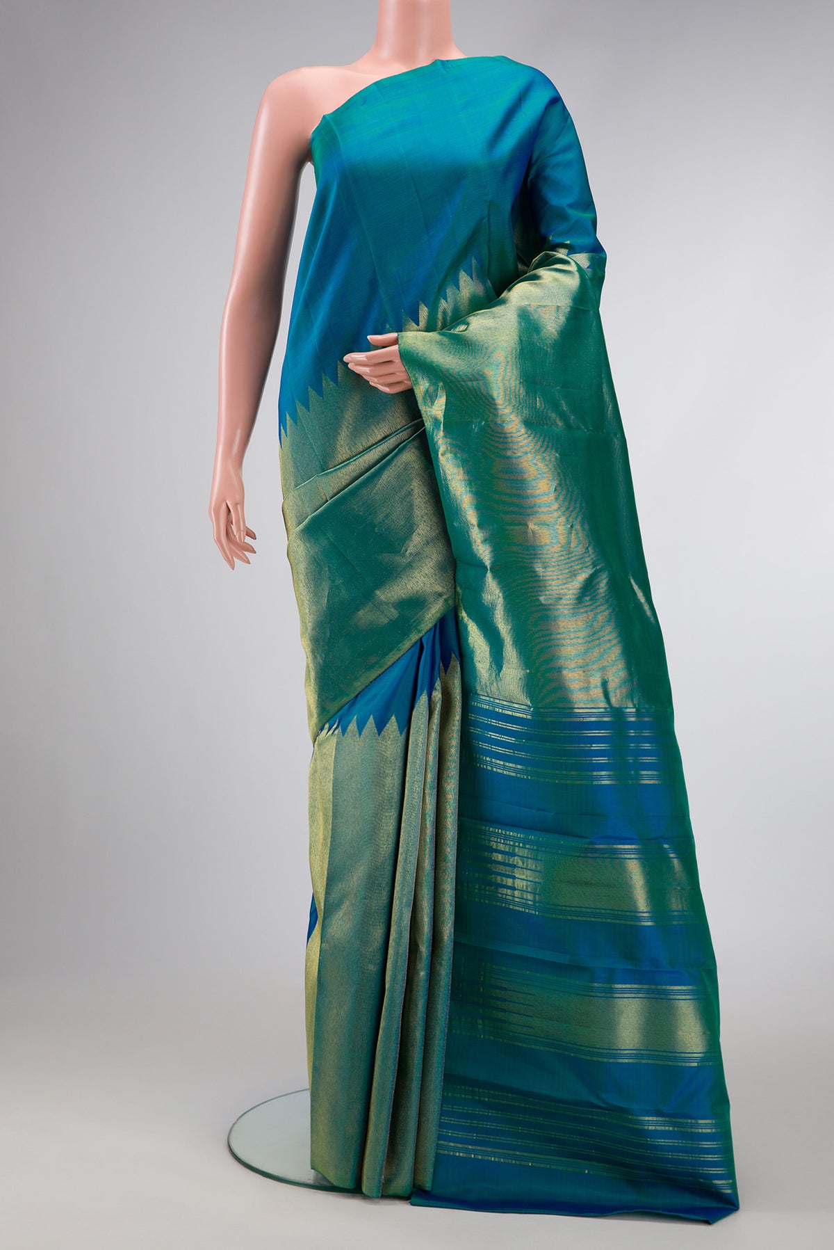Peacock Blue Dual Tone Kanjivaram Silk Saree with Plain Body and Rising Temple Border.  displayed on a mannequin