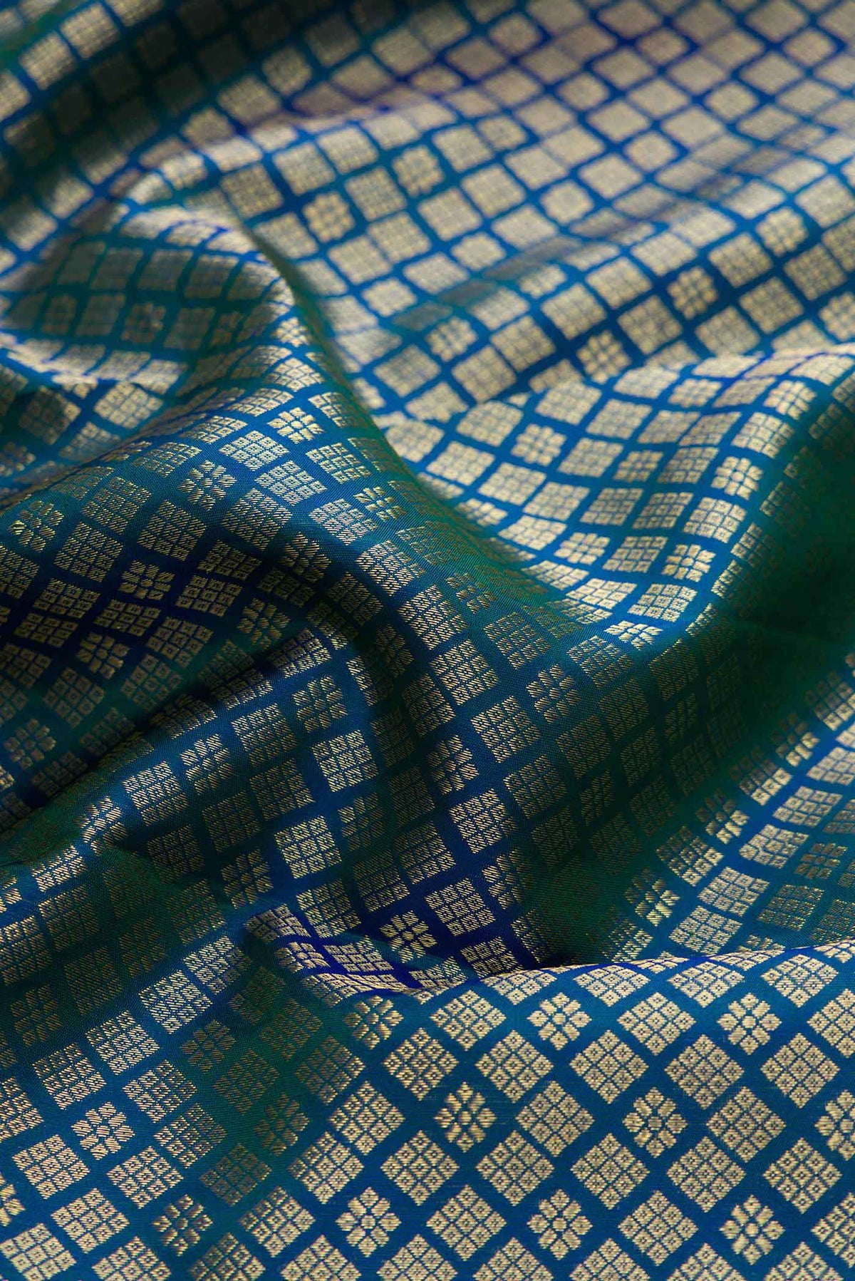 Close up of Peacock Blue Dual Tone Kanchipuram Silk Saree with Zari Brocade on the body and Zari Border displaying folds
