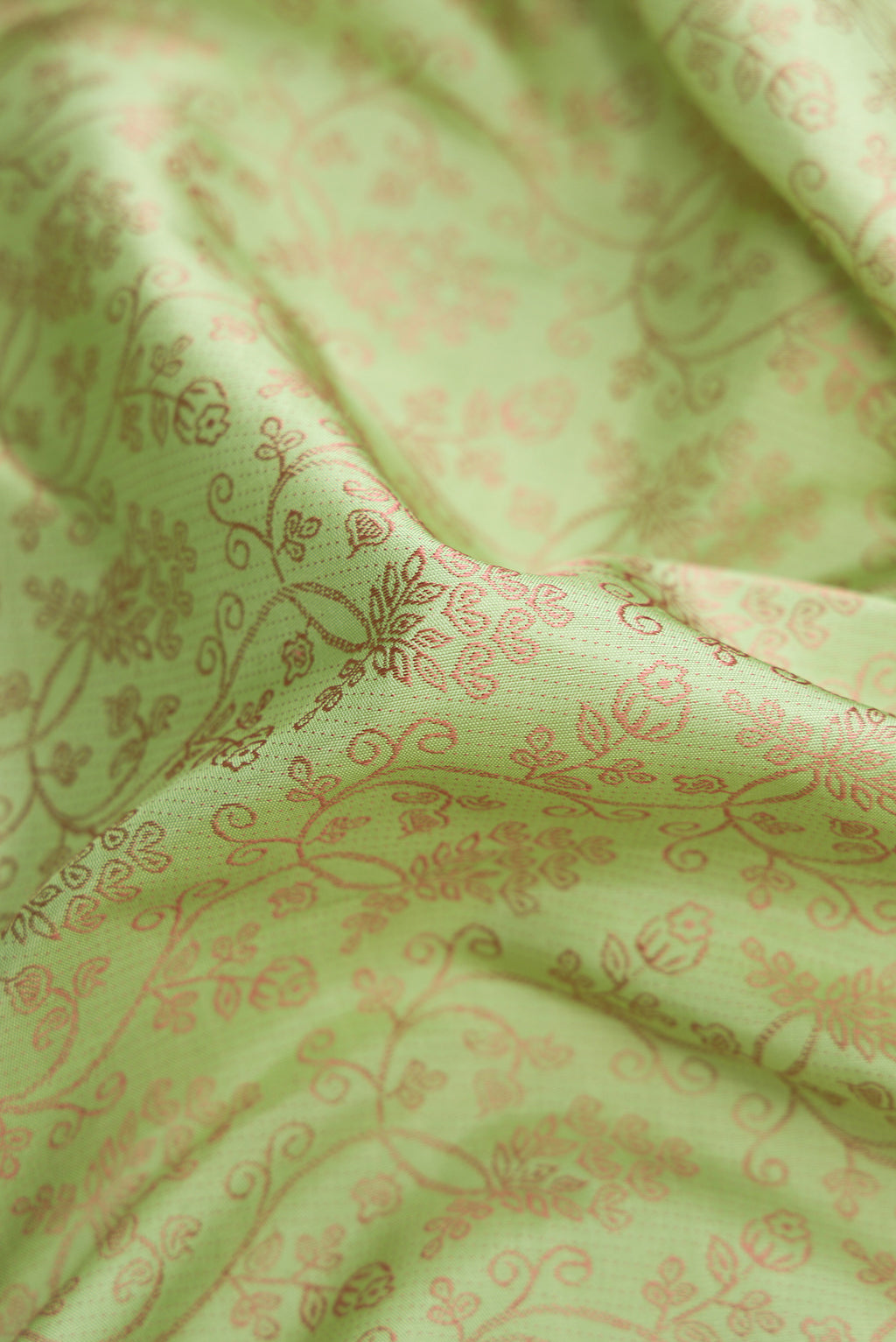 Close up of Pure Silk Pure Zari Pista Green Dual Tone Kanchipuram Saree with Jacquard design on the body and Fancy Border.  displaying folds