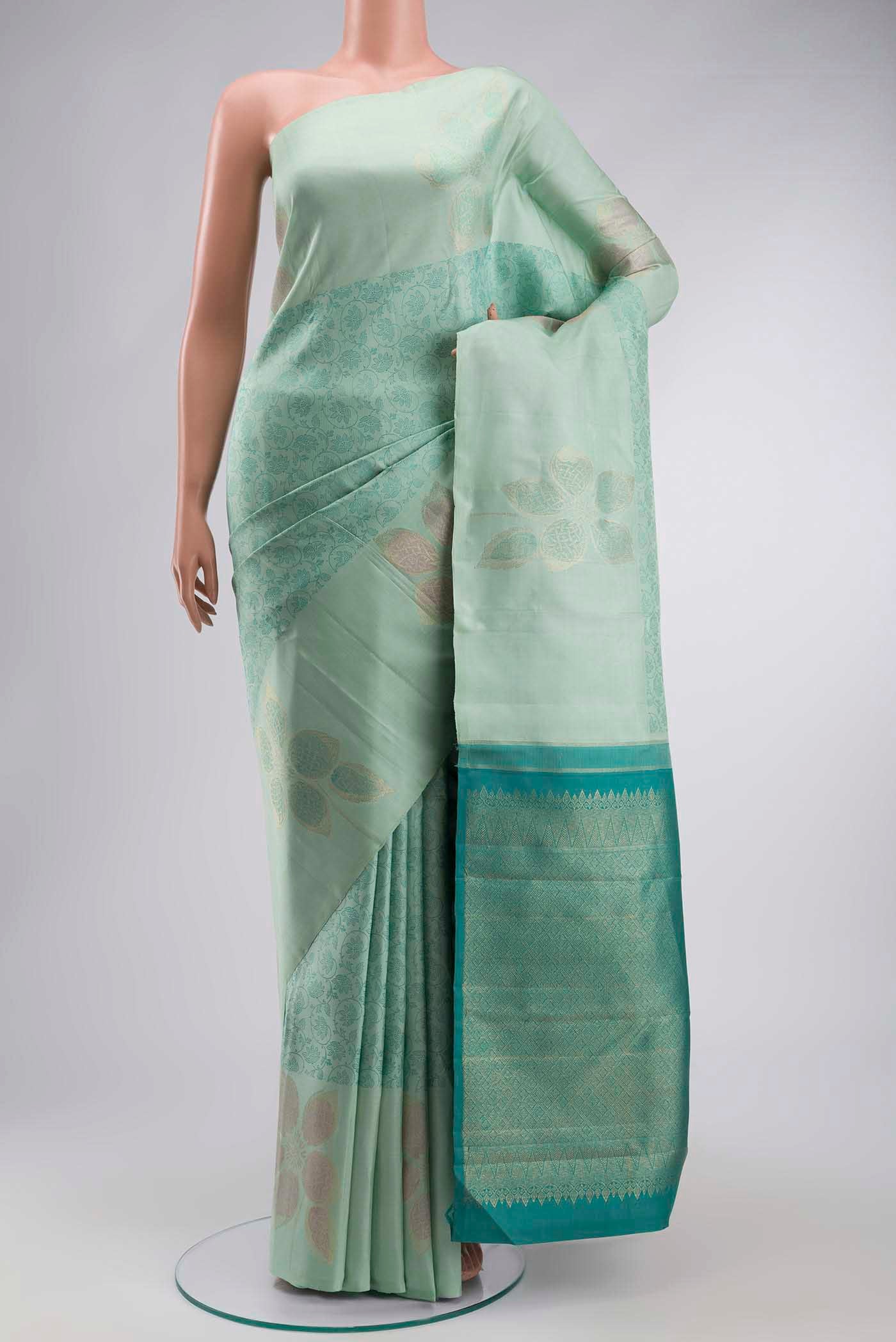 Green Kanchipuram Silk Saree with Jacquard design on the body and Zari Border displayed on a mannequin