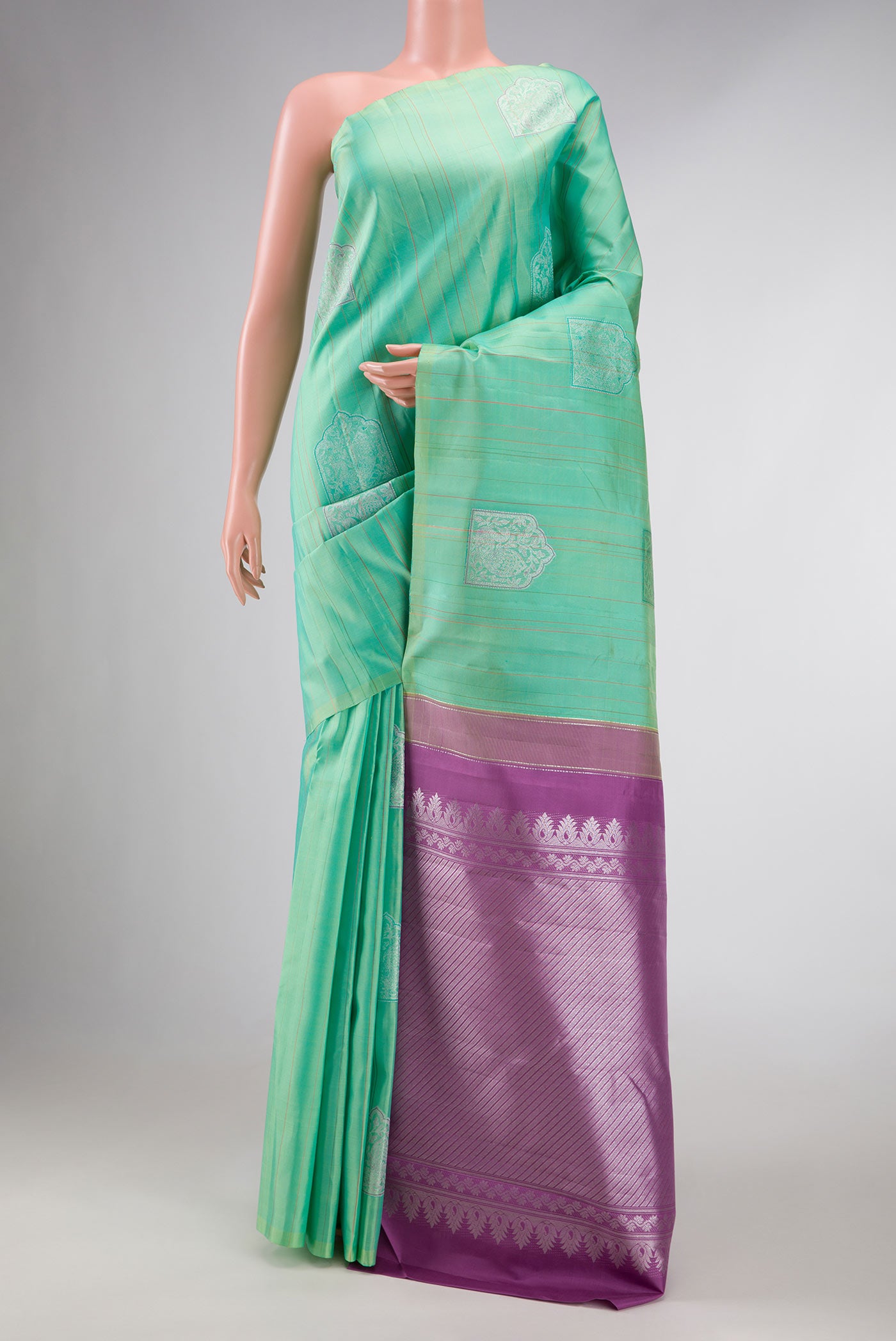 Sea Green Dual Tone Kanchipuram Silk Saree with Zari Butta on the body and Without Border displayed on a mannequin