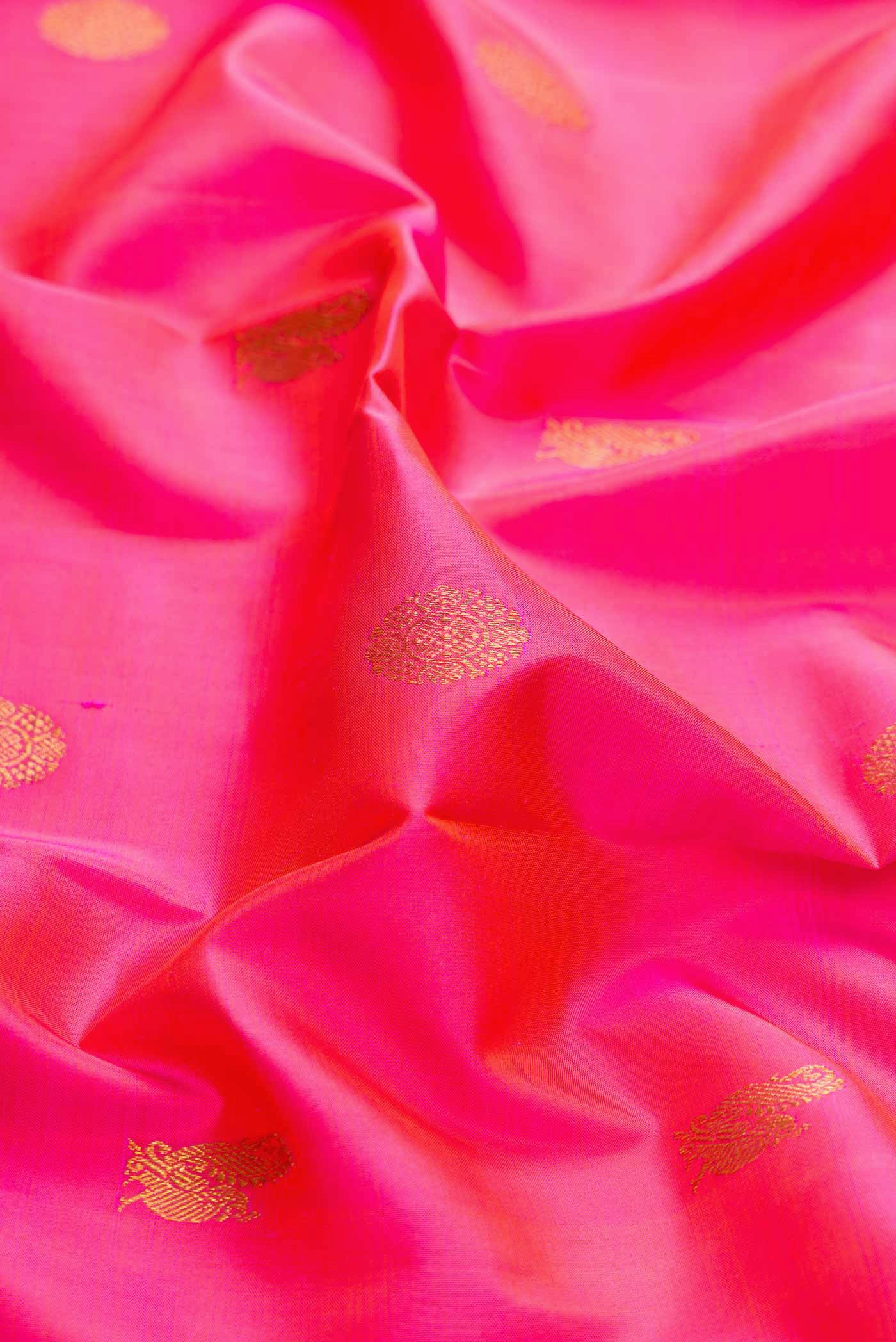 Close up of Pink Dual Tone Kanchipuram Silk Saree with Zari Butta on the body and Zari Border displaying folds