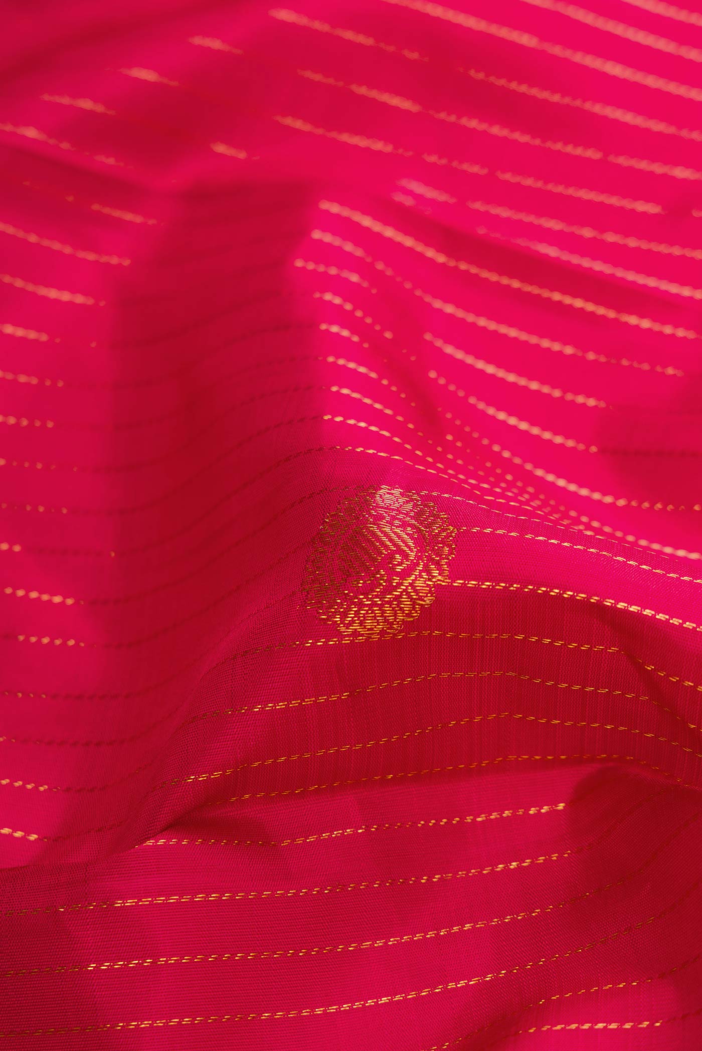 Close up of Dark Pink Dual Tone Kanchipuram Silk Saree with Zari Butta on the body and Zari Border displaying folds