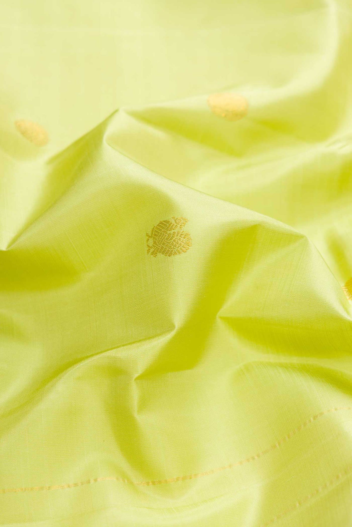 Close up of Green Dual Tone Kanchipuram Silk Saree with Zari Butta on the body and Zari Border displaying folds