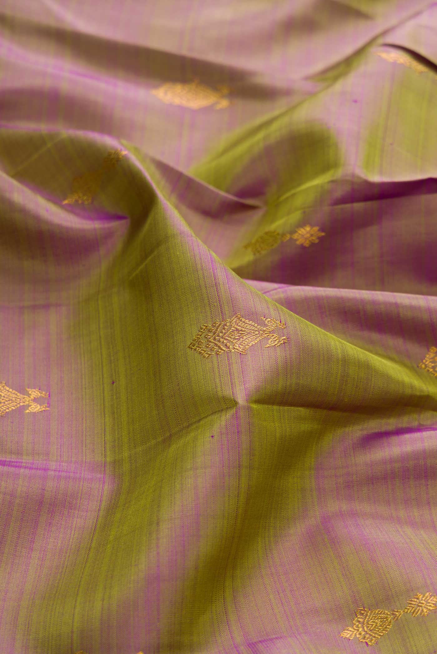 Close up of Green with Purple Color Kanchipuram Silk Saree with Zari Butta on the body and Zari Border displaying folds