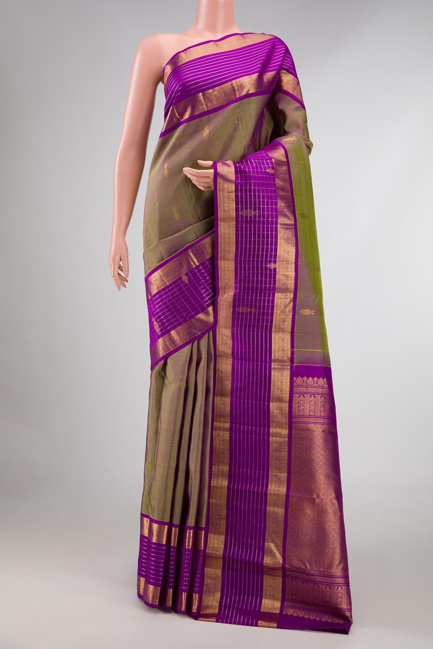 Green with Purple Color Kanchipuram Silk Saree with Zari Butta on the body and Zari Border displayed on a mannequin