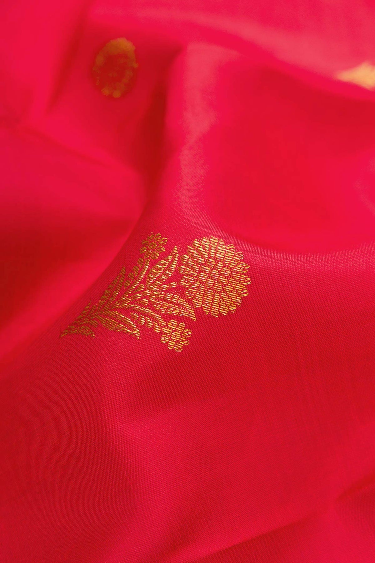 Close up of Red Dual Tone Kanjivaram Silk Saree with Zari Butta on the body and Fancy Border.  displaying folds