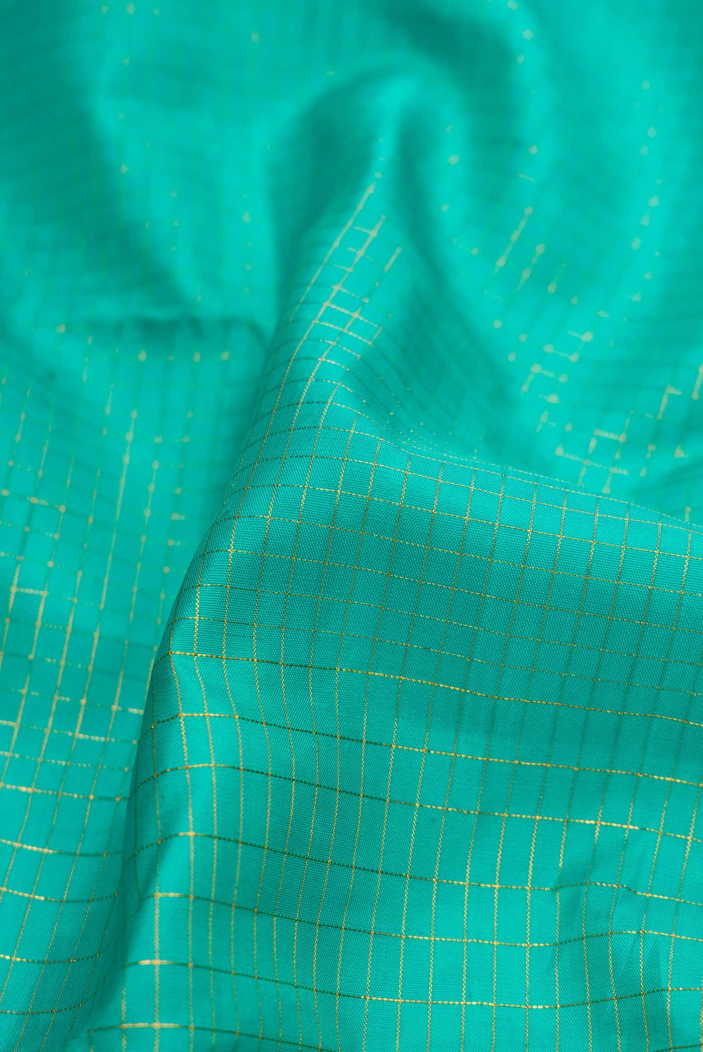 Close up of Sea Green Dual Tone Kanchipuram Silk Saree with Checked design on the body and Fancy Border displaying folds