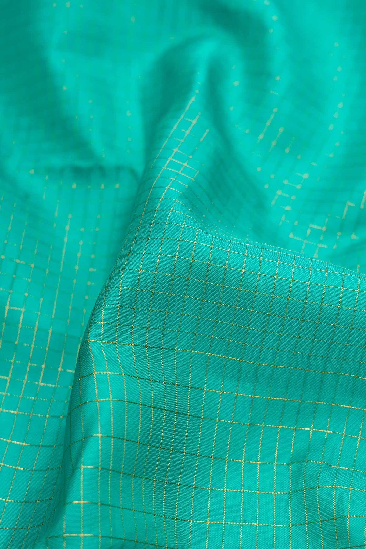 Close up of Sea Green Dual Tone Kanchipuram Silk Saree with Checked design on the body and Fancy Border displaying folds