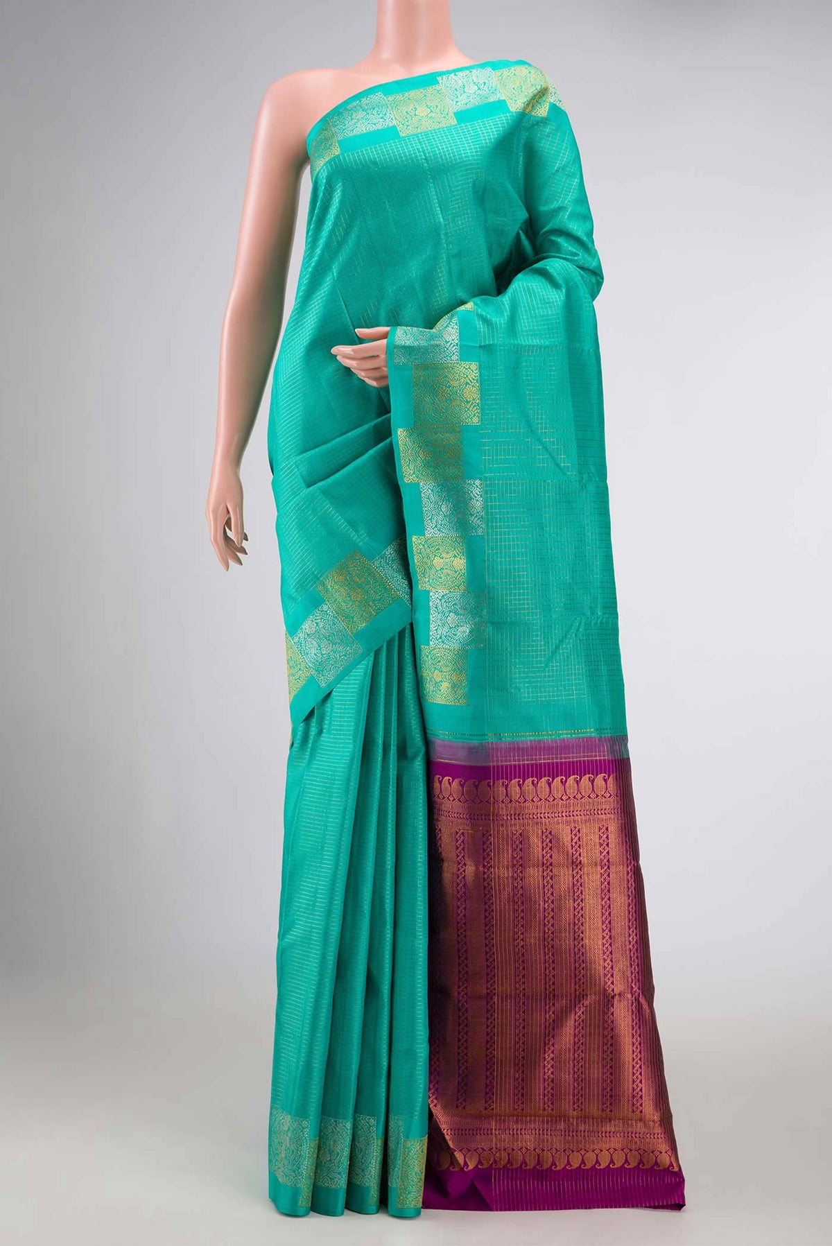 Sea Green Dual Tone Kanchipuram Silk Saree with Checked design on the body and Fancy Border displayed on a mannequin