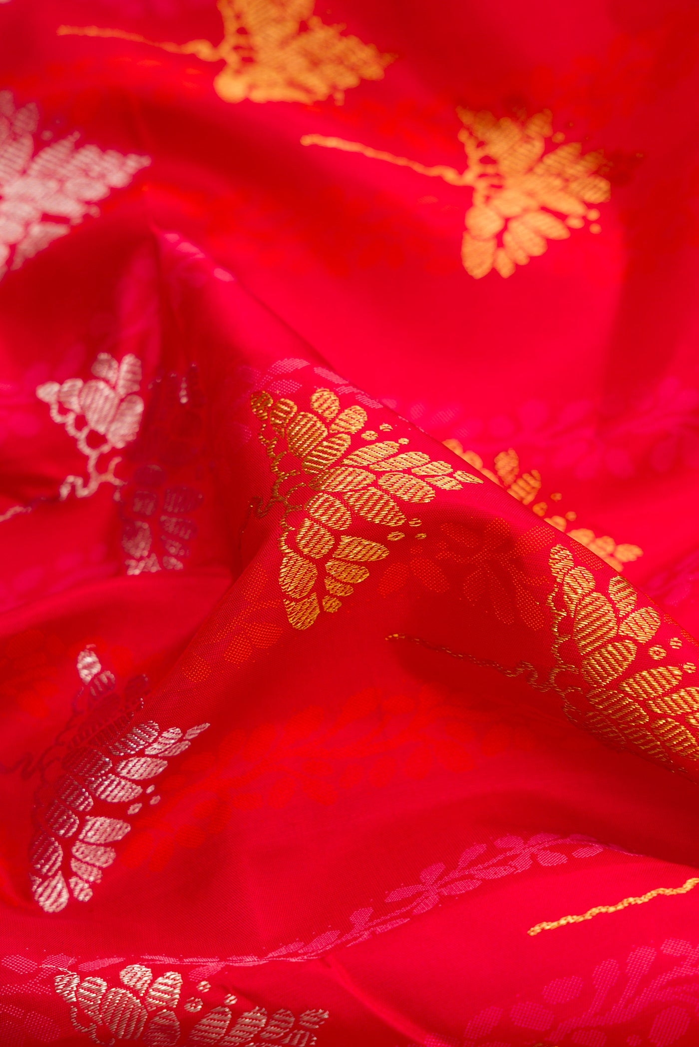 Close up of Pure Silk Pure Zari Red Dual Tone Kanchipuram Saree with Jacquard With Zari Butta on the body and Zari Border.  displaying folds