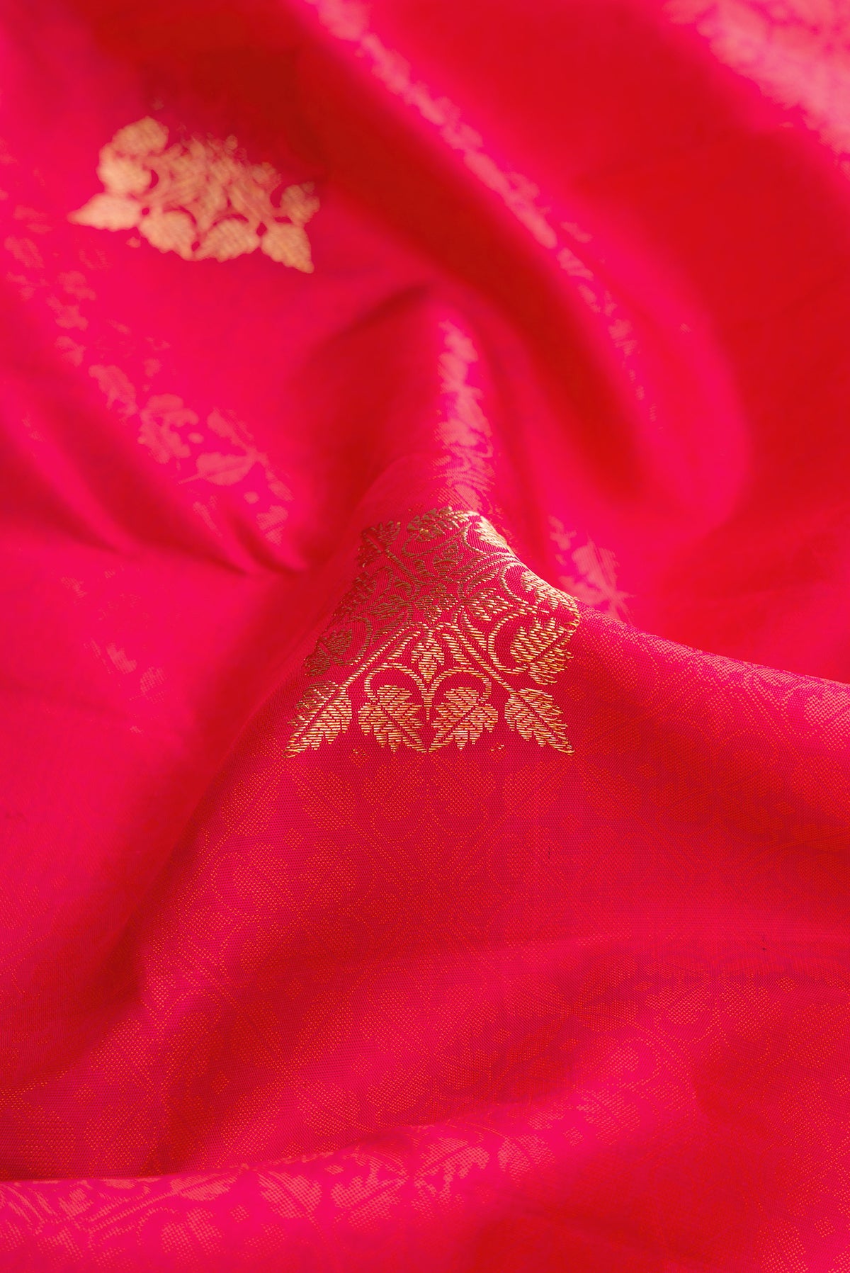 Close up of Red Dual Tone Kanjivaram Silk Saree with Zari Butta on the body and Fancy Border.  displaying folds