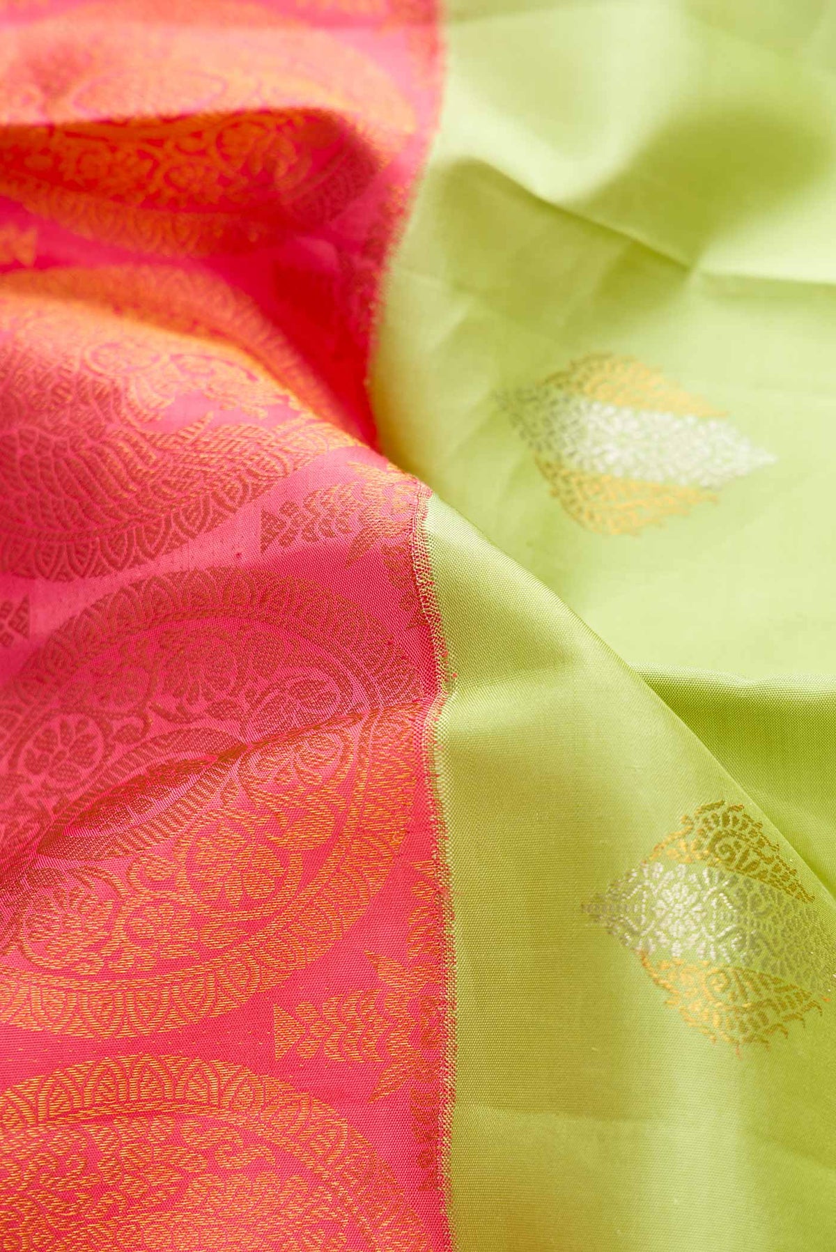 Close up of Pista Green and pink Color Kanchipuram Silk Saree with Half And Half on the body and Without Border displaying folds