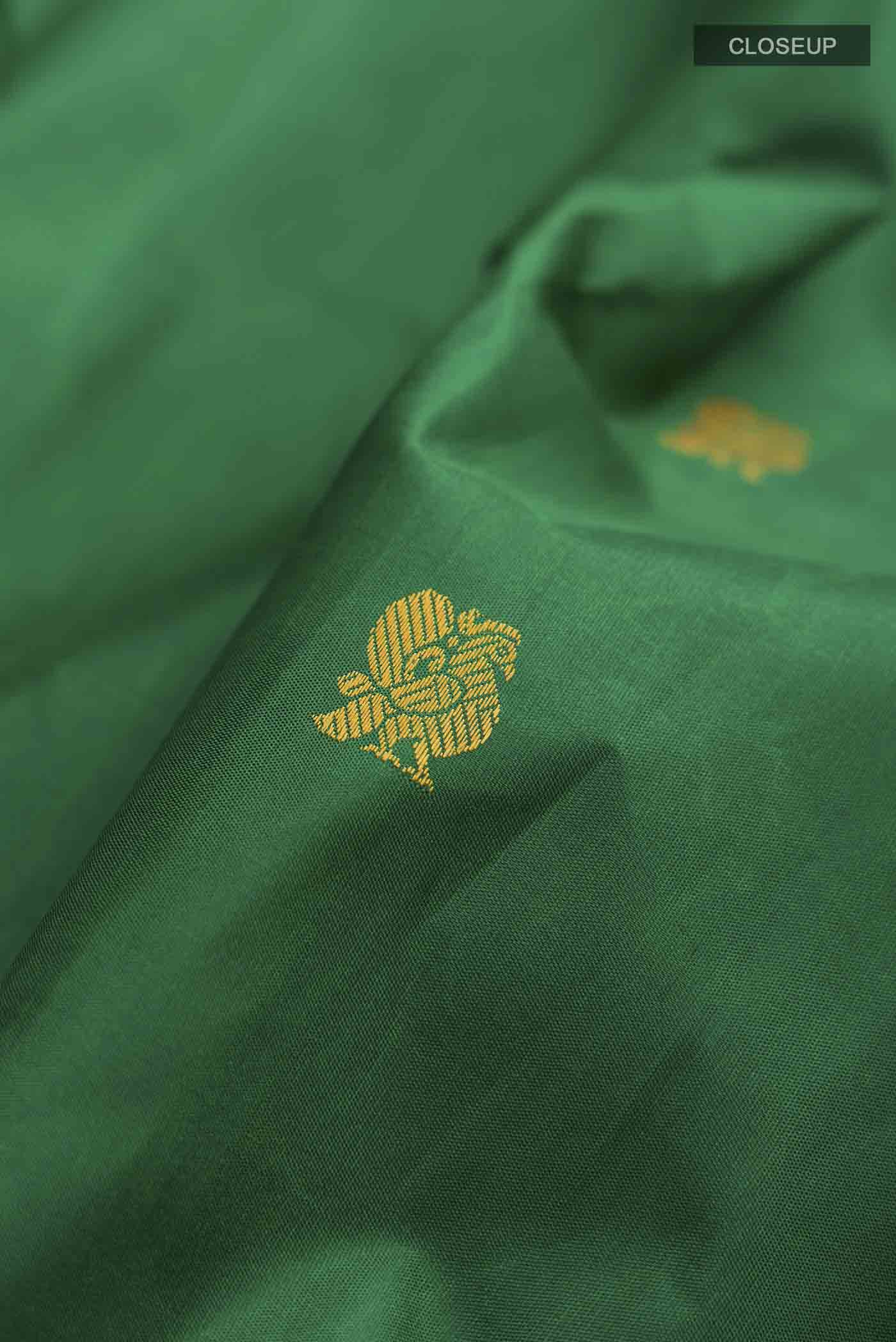 Close up of Green Kanchipuram Silk Saree with Thread Butta on the body and Thread Border displaying folds