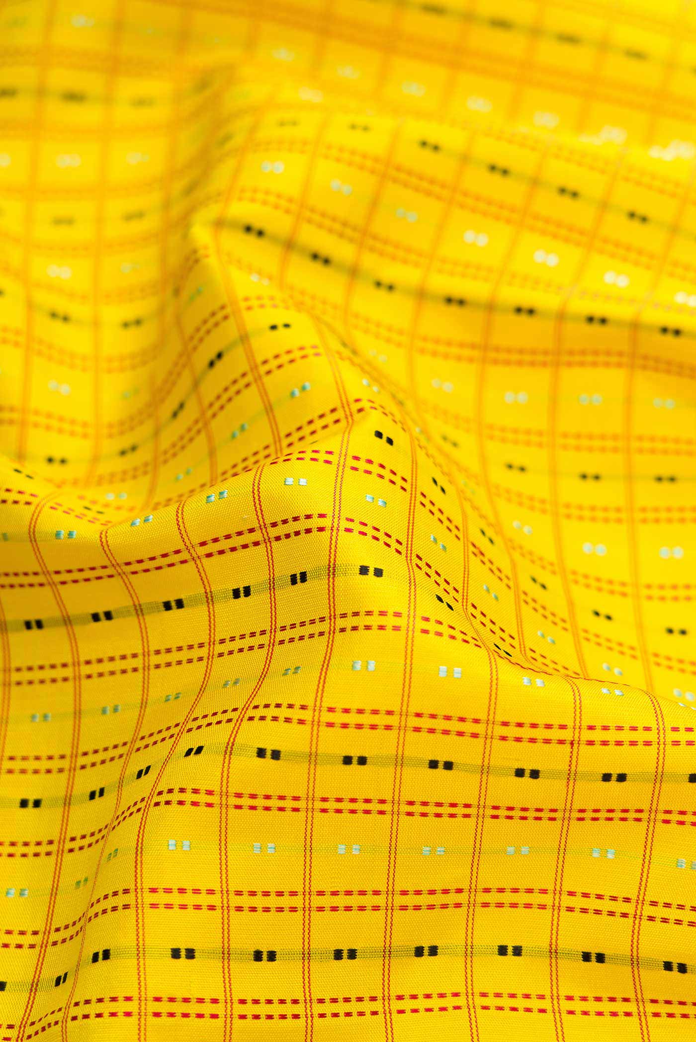 Close up of Yellow Dual Tone Kanchipuram Silk Saree with Checked design on the body and Zari Border.  displaying folds