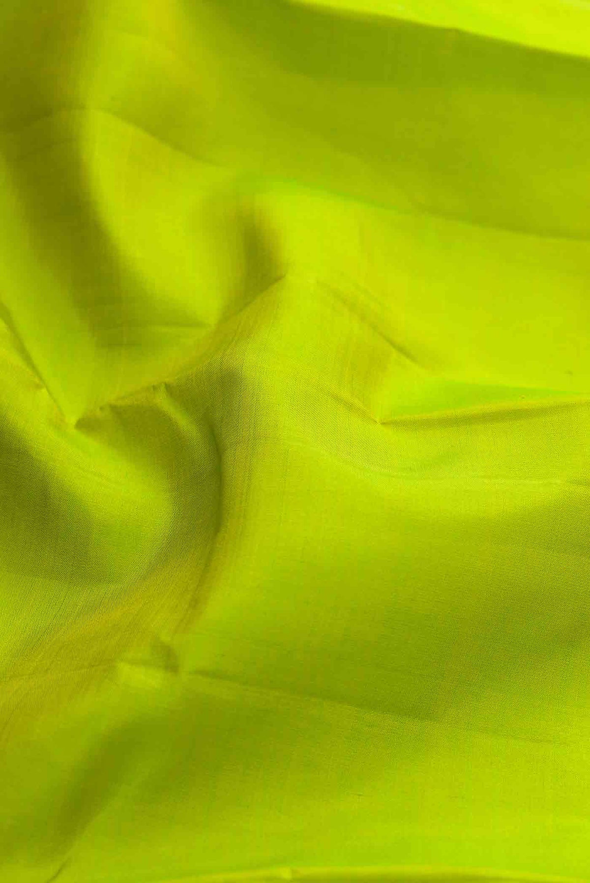 Close up of Parrot Green Dual Tone Kanchipuram Silk Saree with Plain Body and Zari Border displaying folds