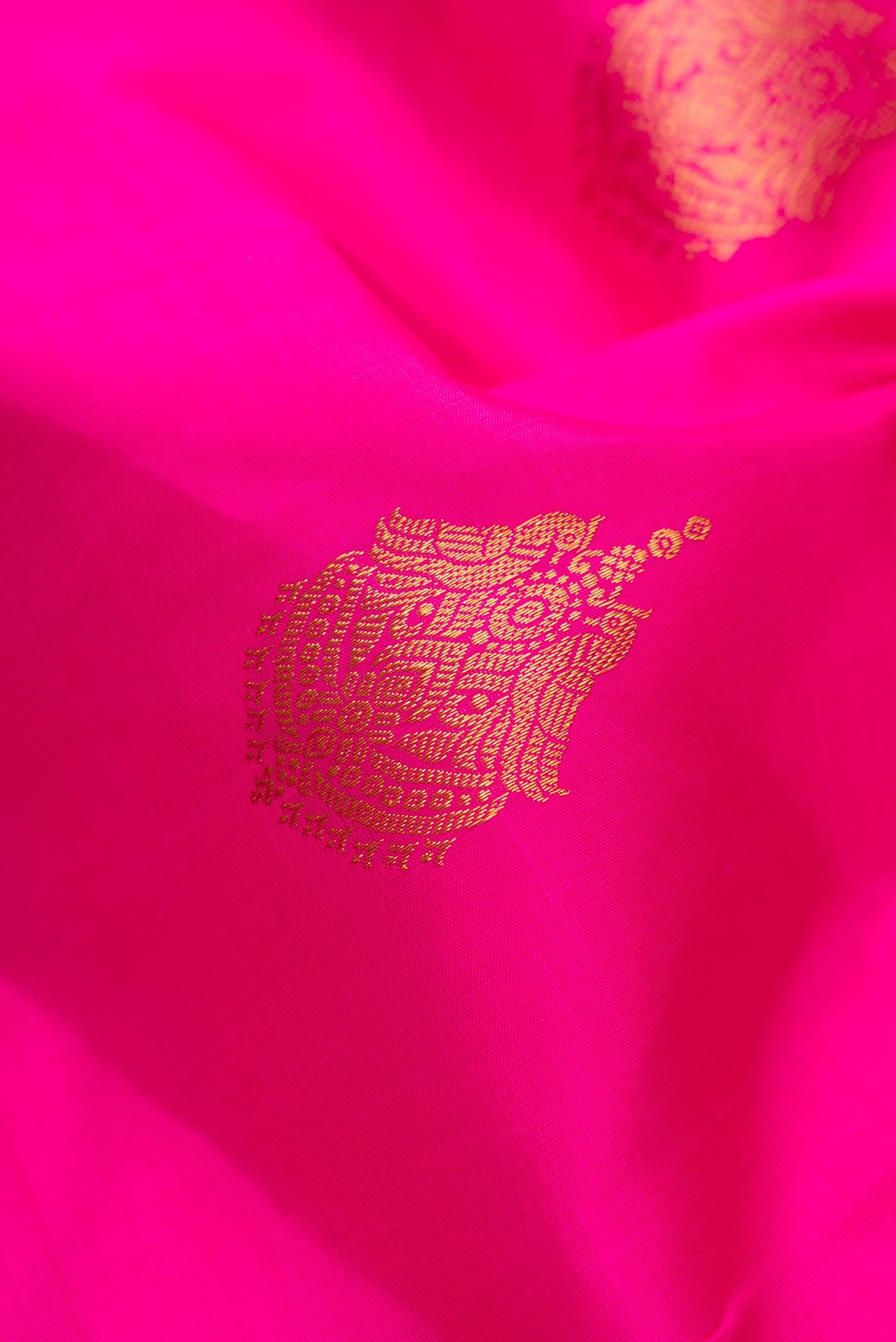 Close up of Pink Dual Tone Kanjivaram Silk Saree with Zari Butta on the body and Zari Border.  displaying folds