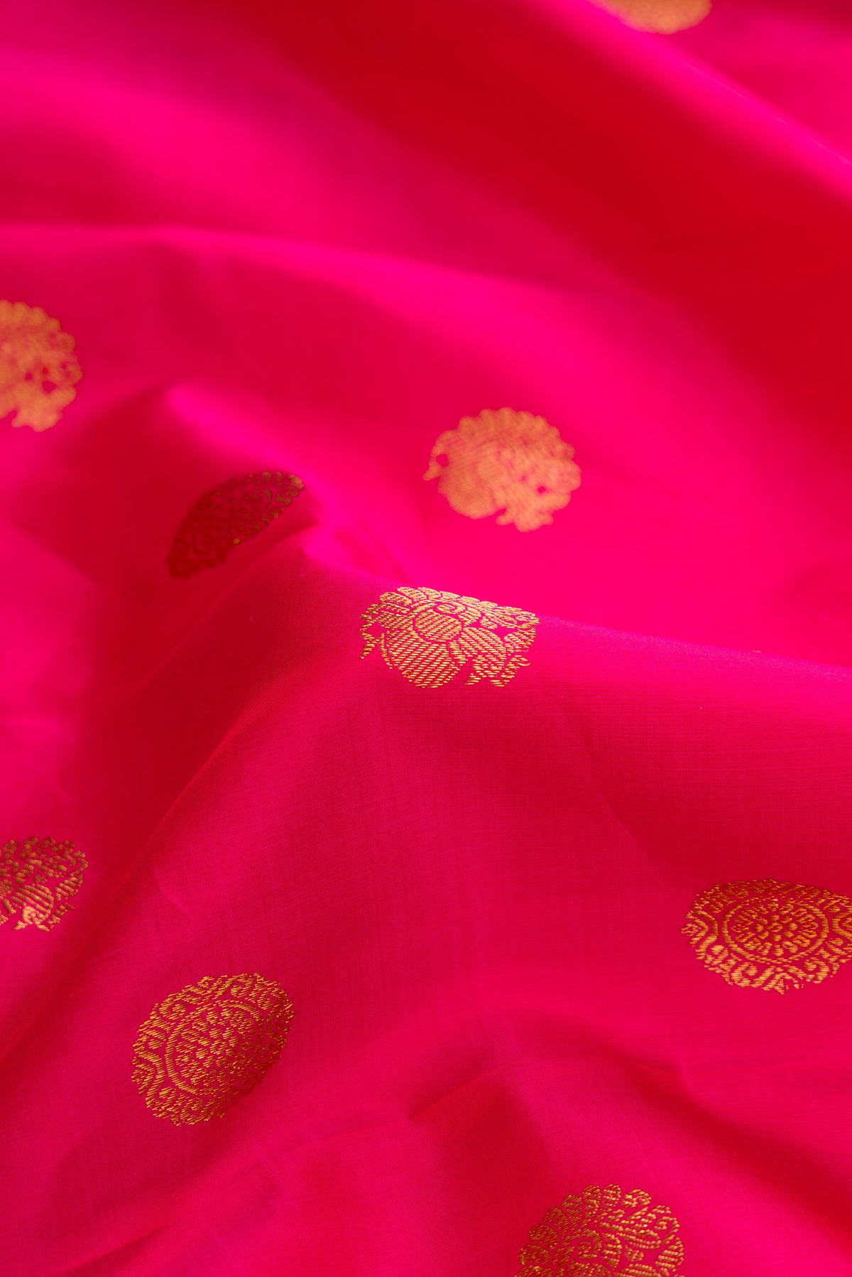 Close up of Pink Dual Tone Kanjivaram Silk Saree with Zari Butta on the body and Zari Border.  displaying folds