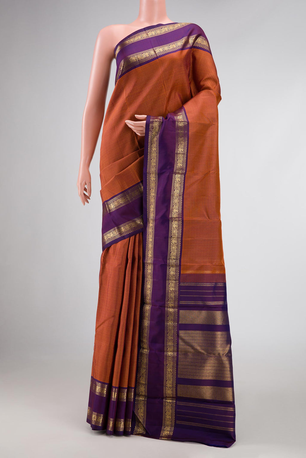Brick Orange Dual Tone Kanchipuram Silk Saree with Stripes on the body and Zari Border displayed on a mannequin