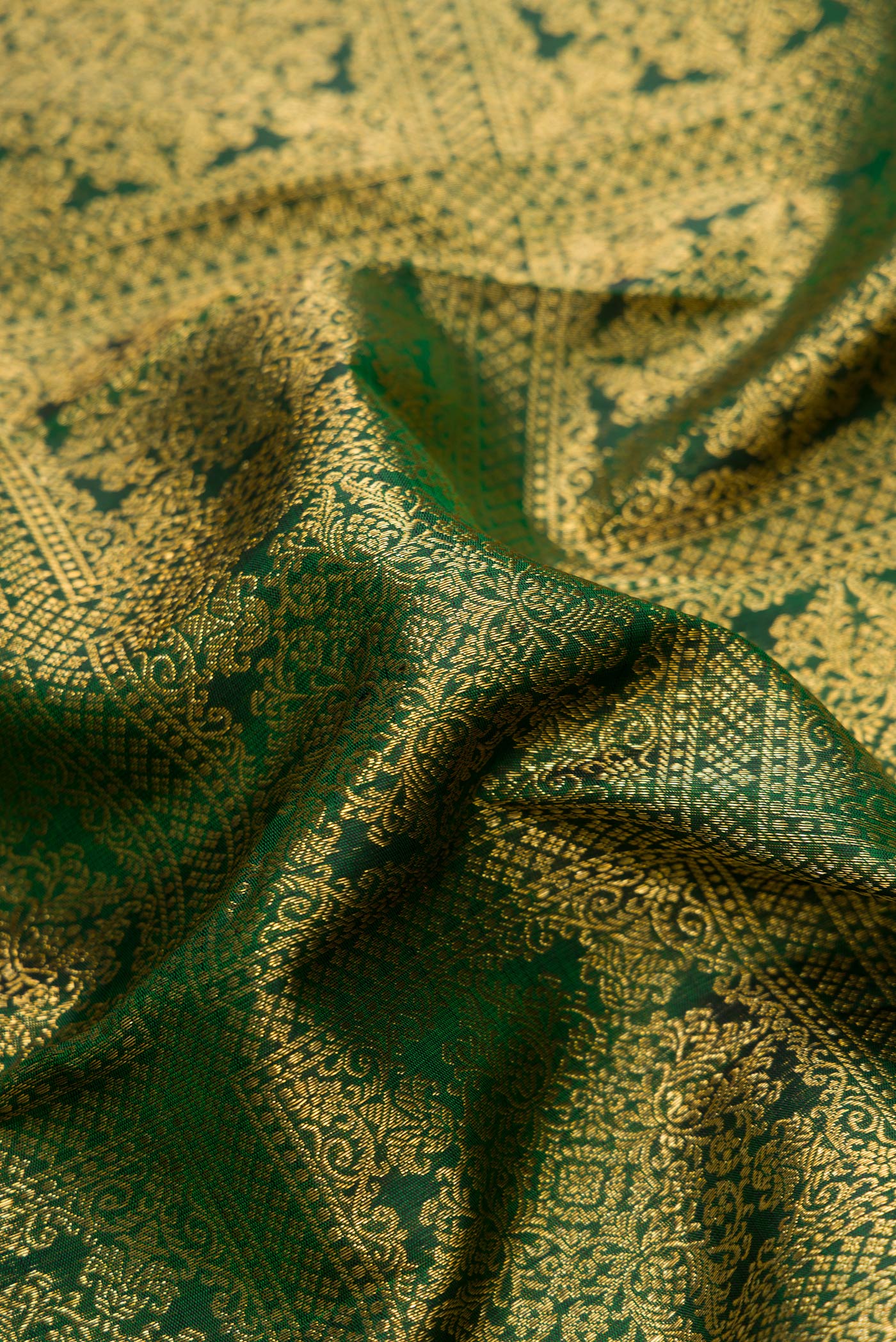 Close up of Green Dual Tone Kanjivaram Silk Saree with Zari Brocade on the body and Zari Border.  displaying folds