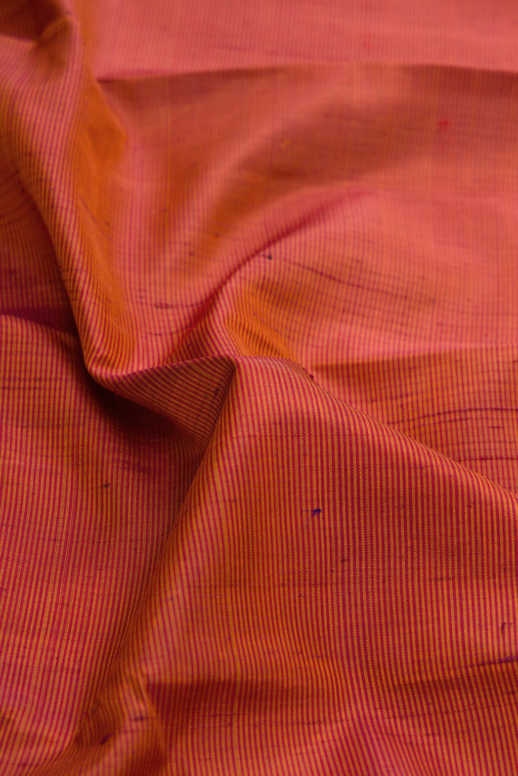 Close up of Brick Orange Dual Tone Kanjivaram Silk Saree with Stripes on the body and Zari Border.  displaying folds