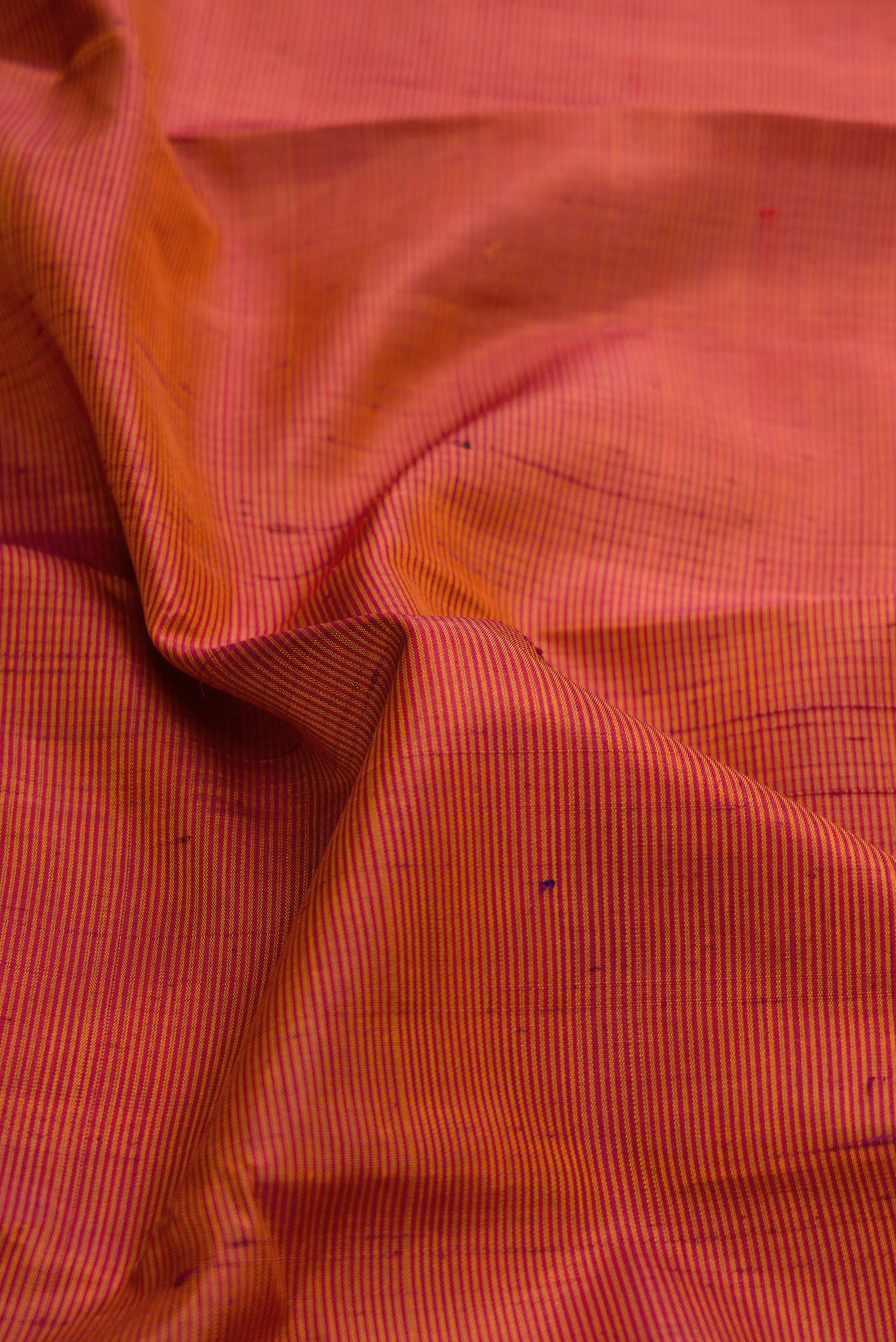 Close up of Brick Orange Dual Tone Kanjivaram Silk Saree with Stripes on the body and Zari Border.  displaying folds