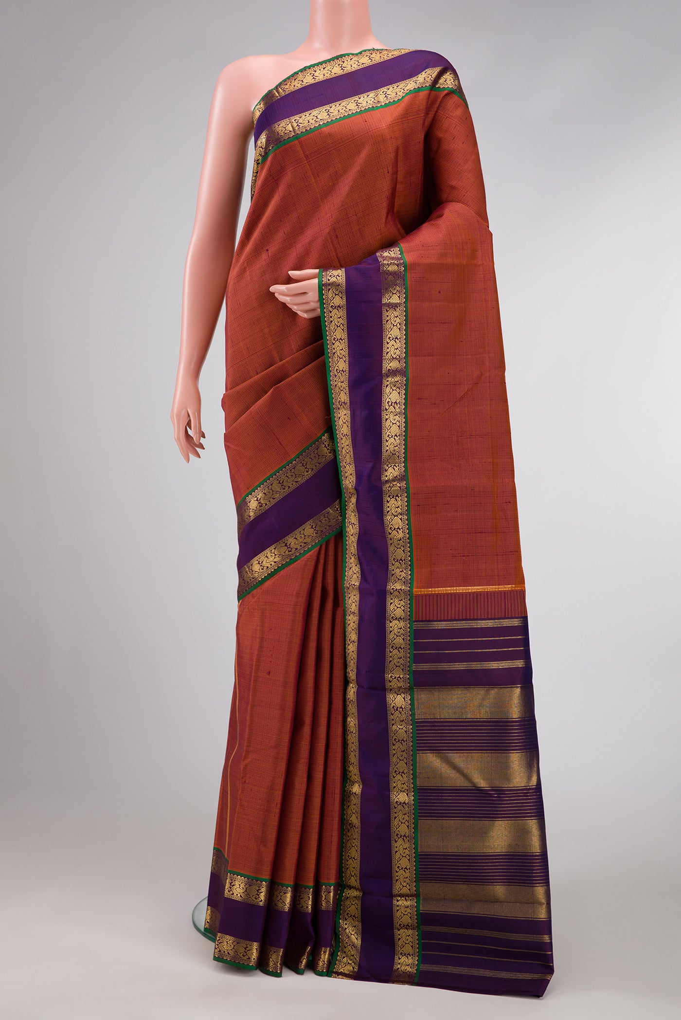 Brick Orange Dual Tone Kanjivaram Silk Saree with Stripes on the body and Zari Border.  displayed on a mannequin