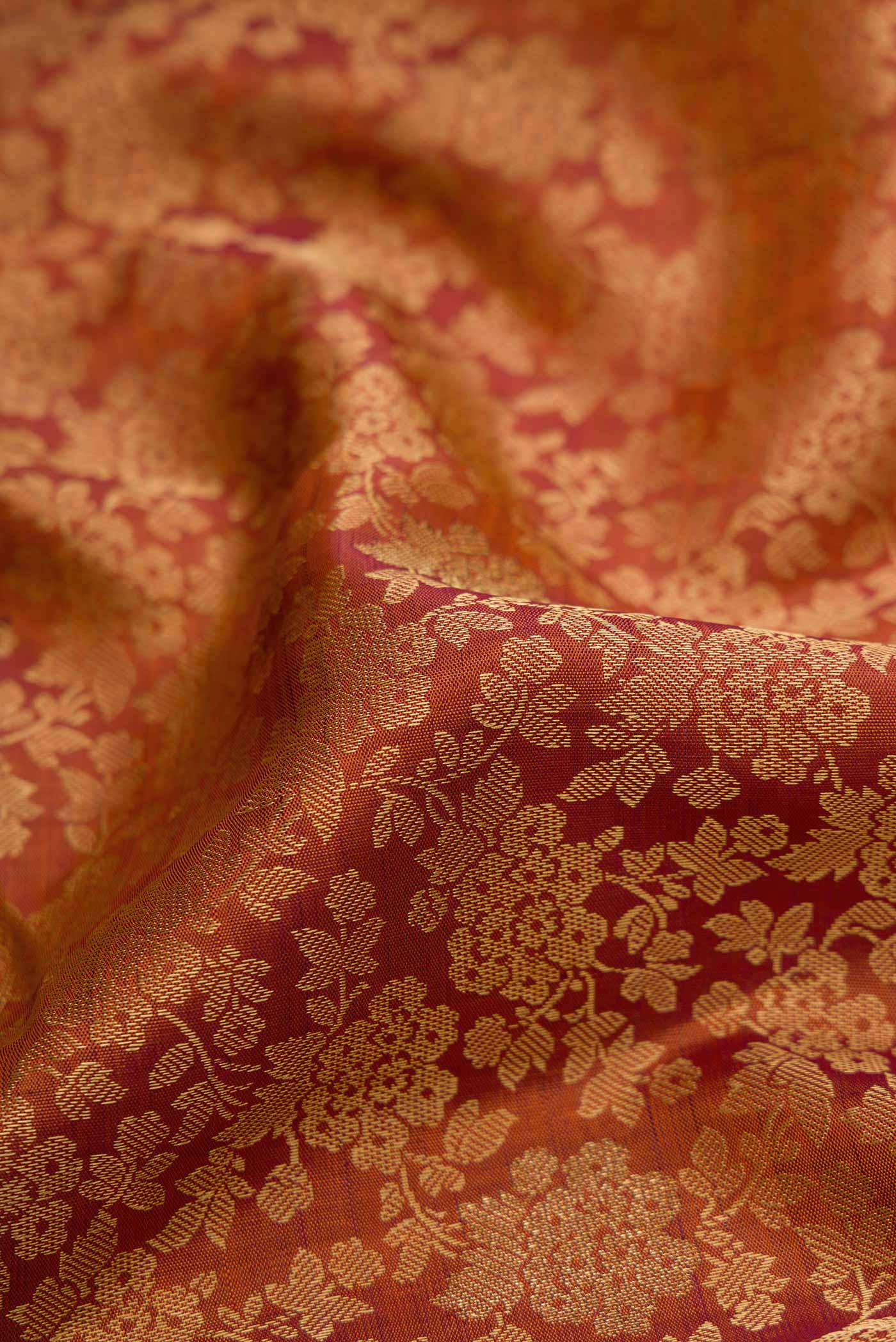 Close up of Brick Orange Dual Tone Kanchipuram Silk Saree with Jacquard design on the body and Zari Border displaying folds