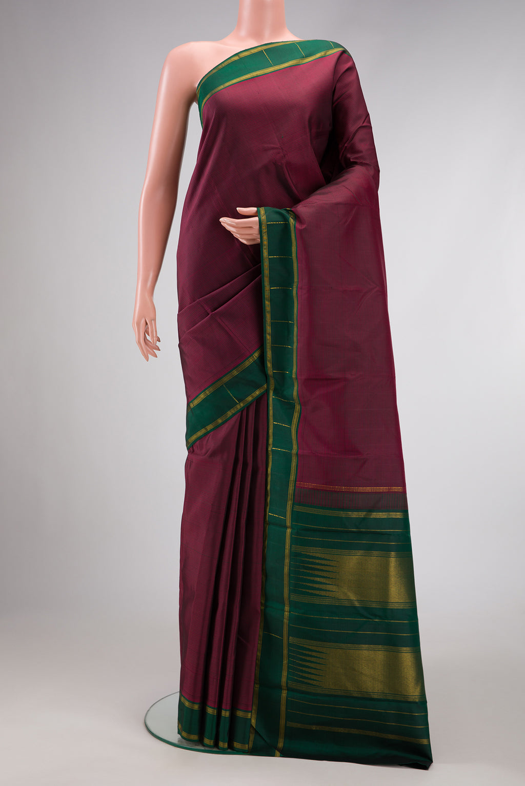 Maroon Dual Tone Kanchipuram Silk Saree with Stripes on the body and Zari Border.  displayed on a mannequin