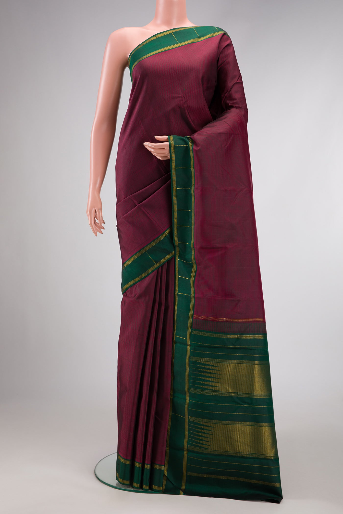 Maroon Dual Tone Kanchipuram Silk Saree with Stripes on the body and Zari Border.  displayed on a mannequin