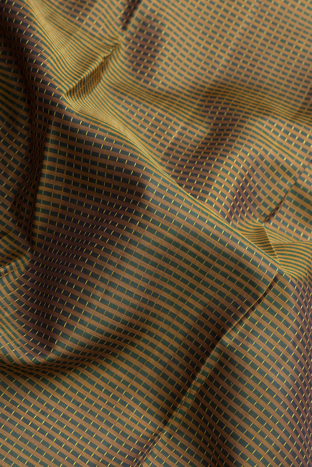 Close up of Bottle Green Dual Tone Kanchipuram Silk Saree with Checked design on the body and Zari Border.  displaying folds