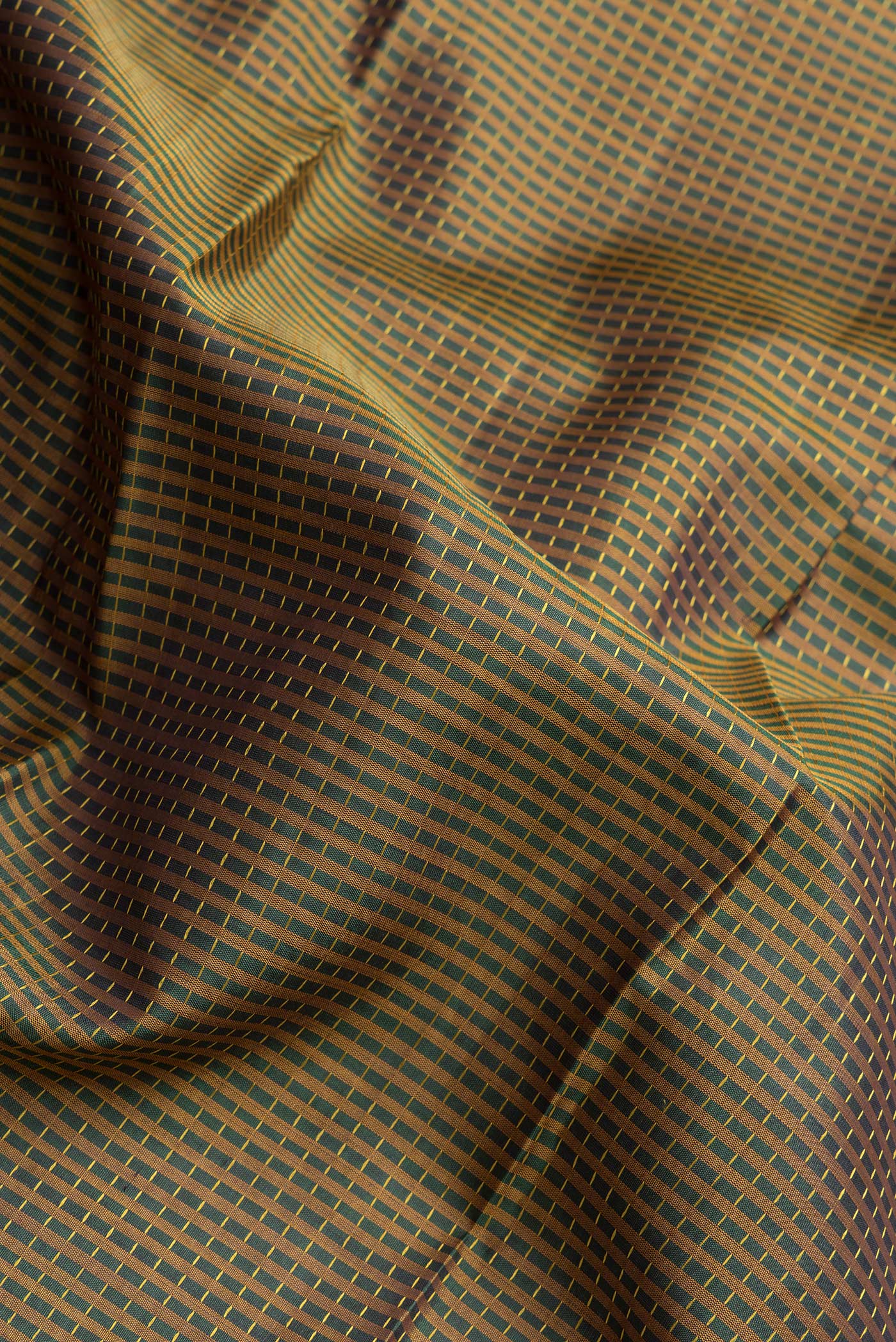 Close up of Bottle Green Dual Tone Kanchipuram Silk Saree with Checked design on the body and Zari Border.  displaying folds