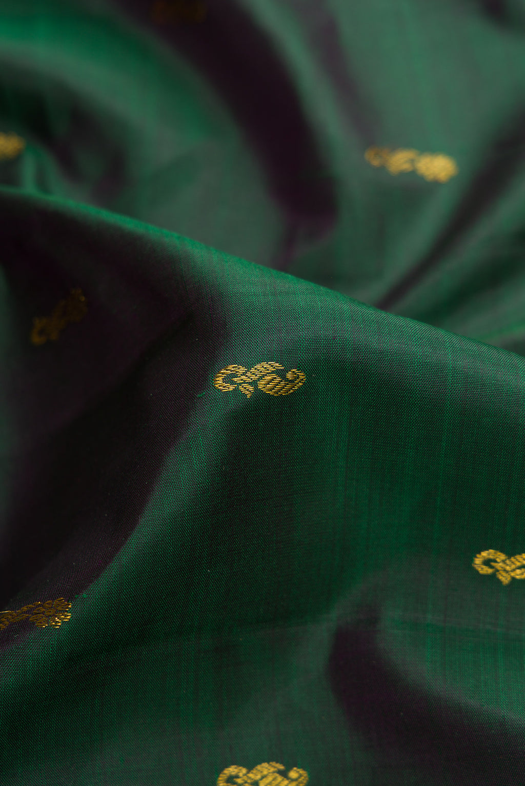 Close up of Bottle Green Dual Tone Kanjivaram Silk Saree with Zari Butta on the body and Zari Border.  displaying folds