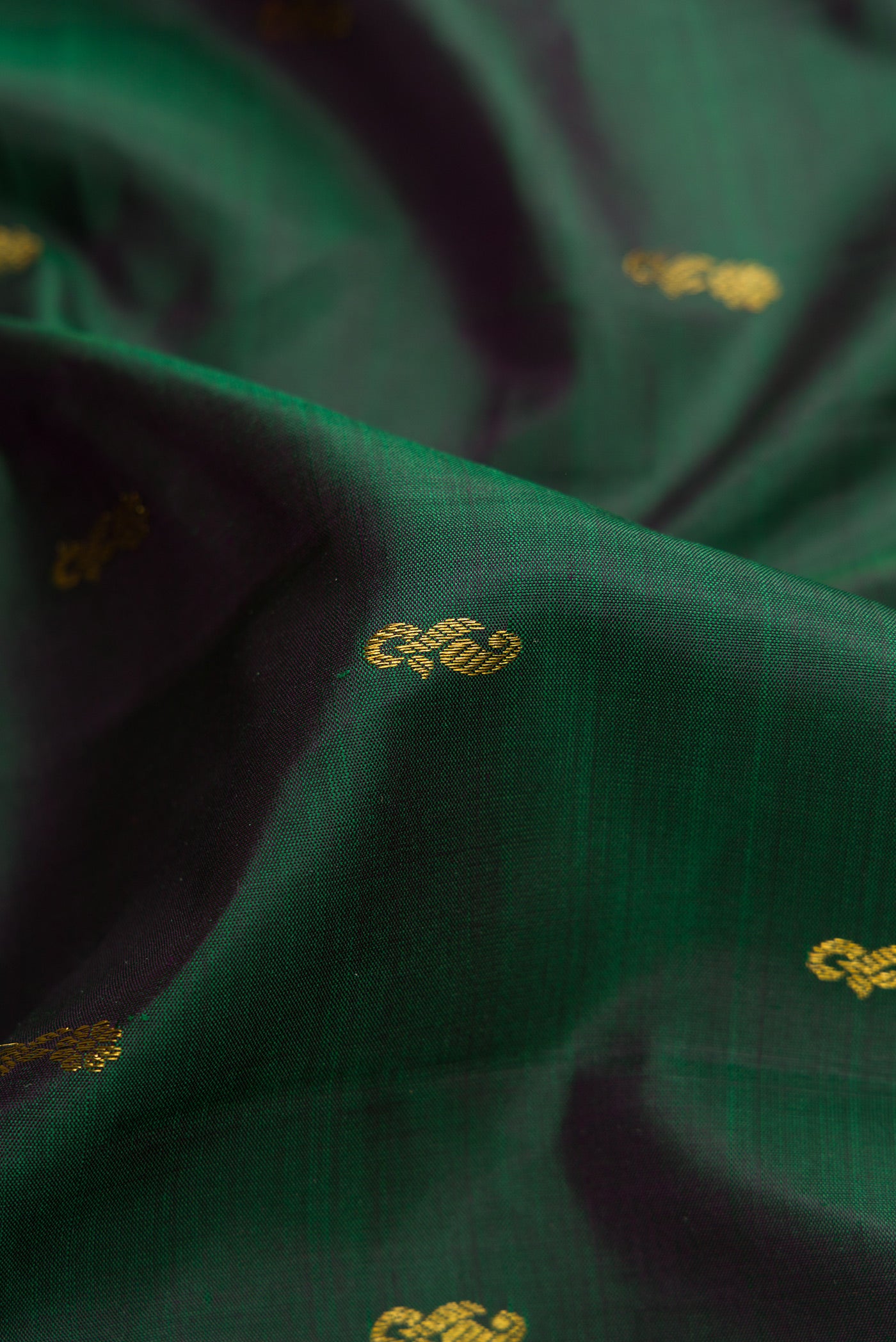 Close up of Bottle Green Dual Tone Kanjivaram Silk Saree with Zari Butta on the body and Zari Border.  displaying folds