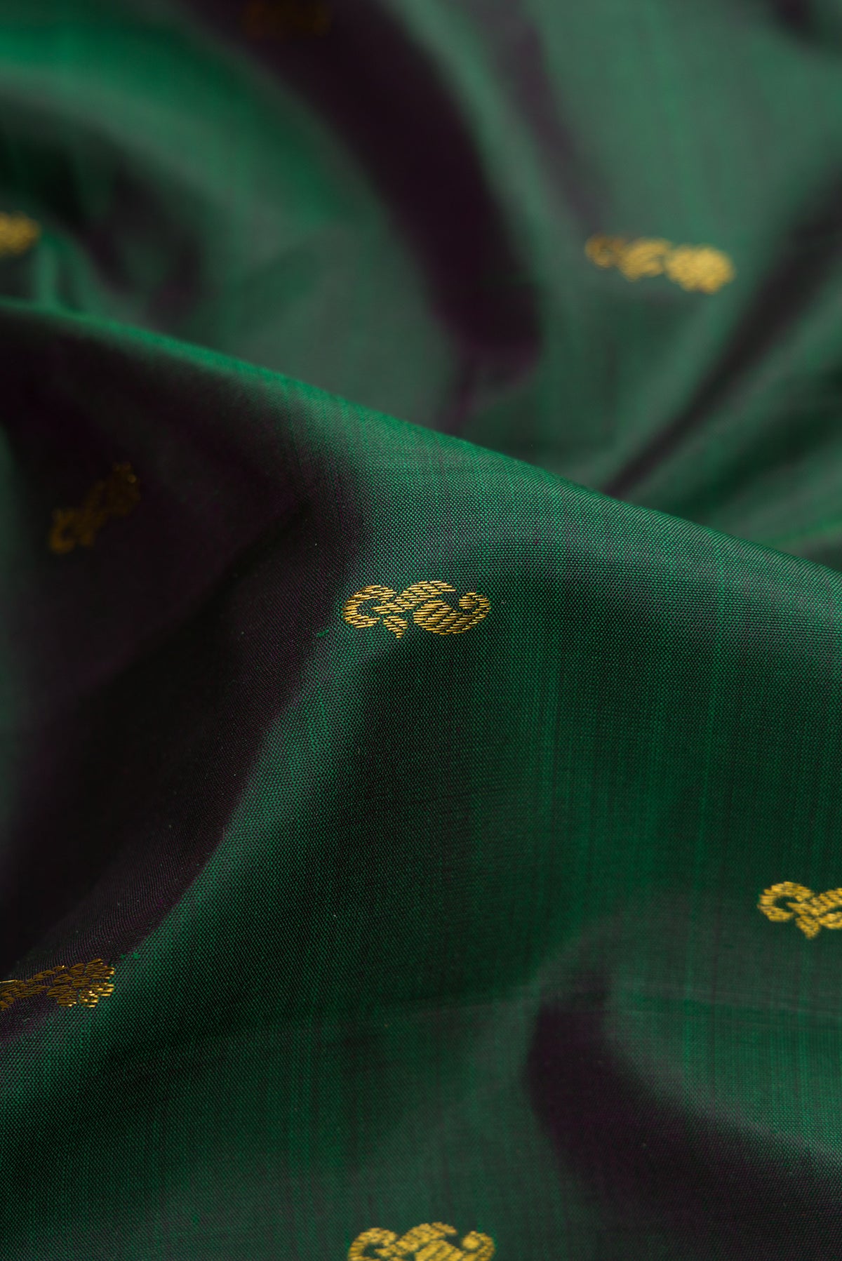 Close up of Bottle Green Dual Tone Kanjivaram Silk Saree with Zari Butta on the body and Zari Border.  displaying folds