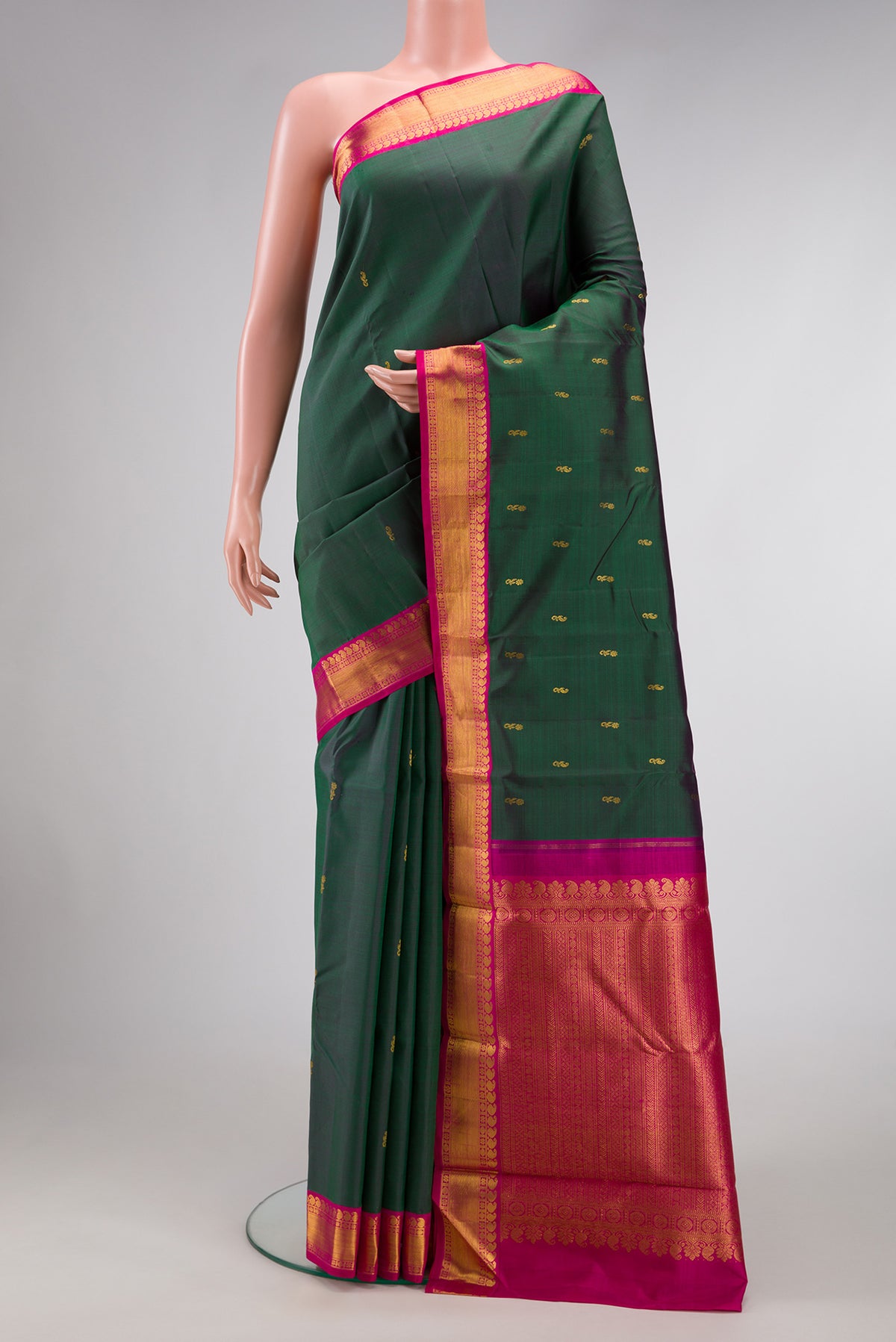 Bottle Green Dual Tone Kanjivaram Silk Saree with Zari Butta on the body and Zari Border.  displayed on a mannequin