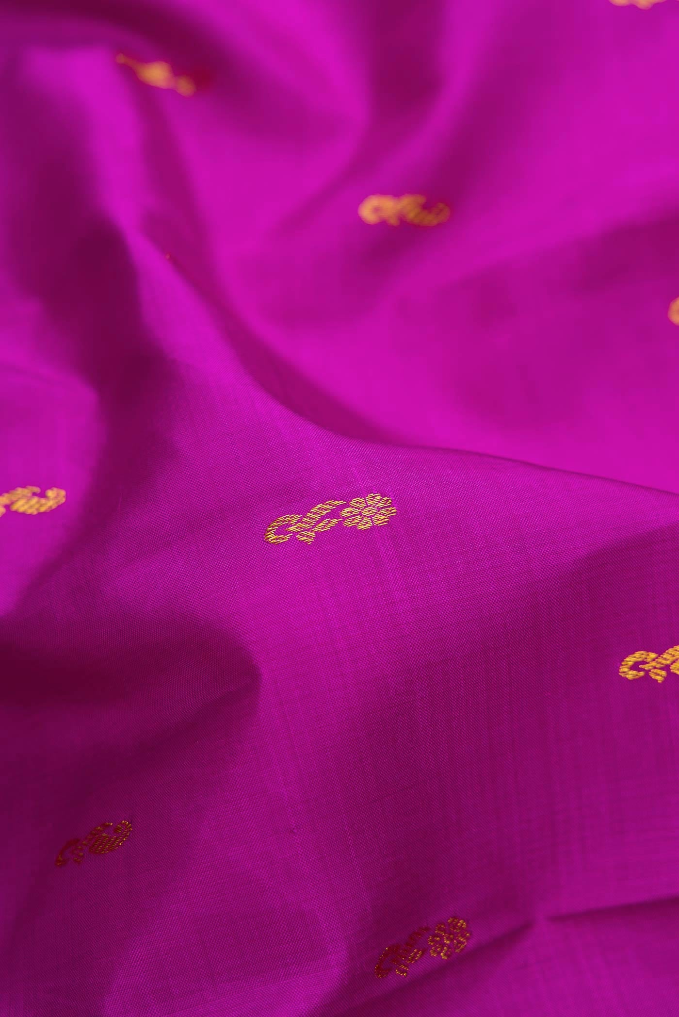 Close up of Magenta Dual Tone Kanjivaram Silk Saree with Zari Butta on the body and Zari Border.  displaying folds