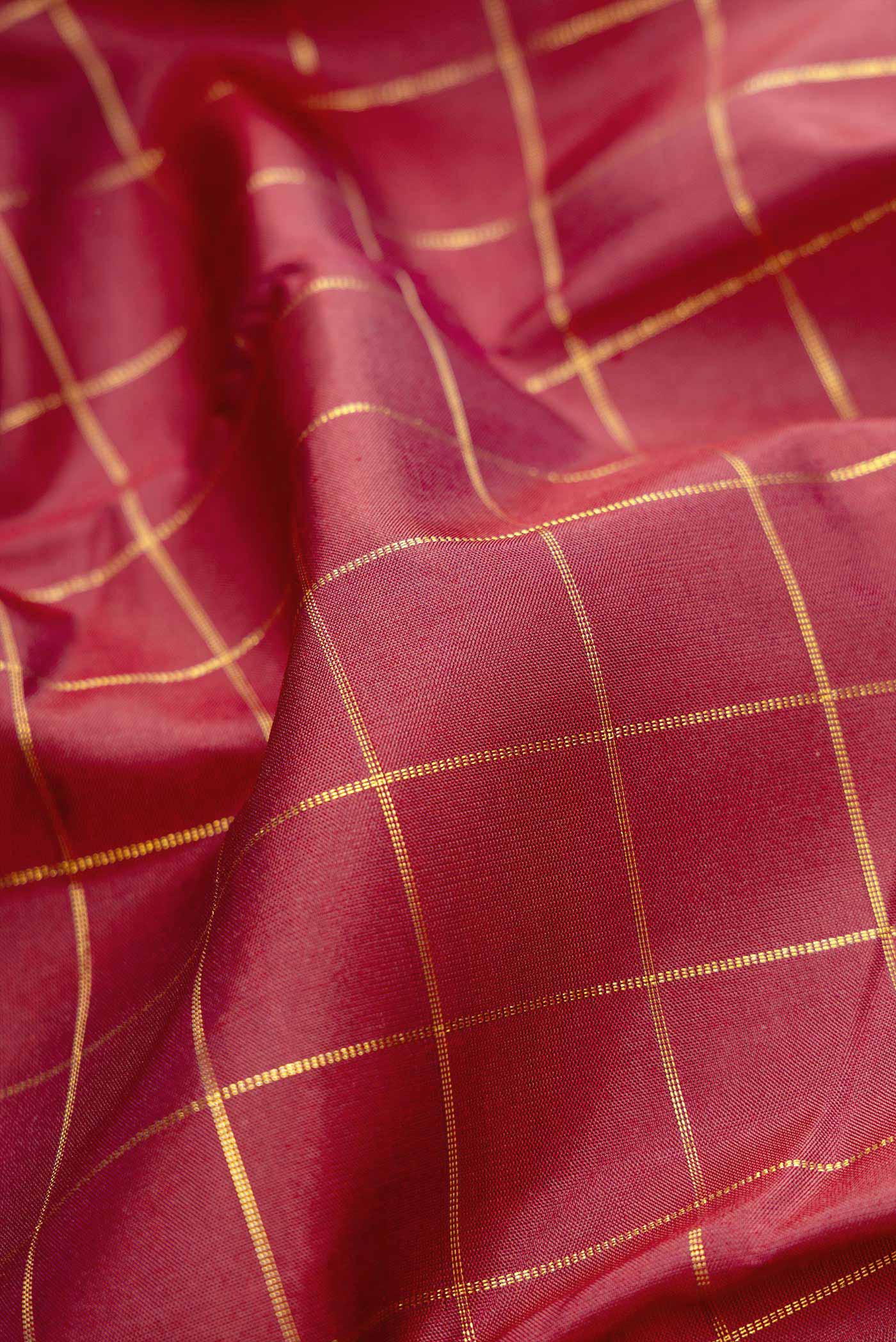 Close up of Maroon Dual Tone Kanchipuram Silk Saree with Checked design on the body and Zari Border displaying folds