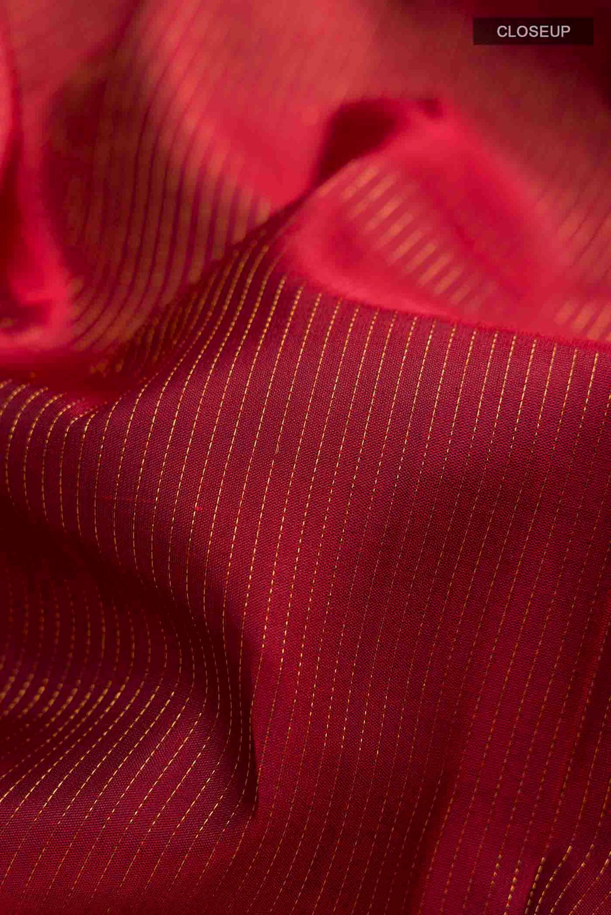Close up of Maroon Kanchipuram Silk Saree with Stripes on the body and Zari Border displaying folds